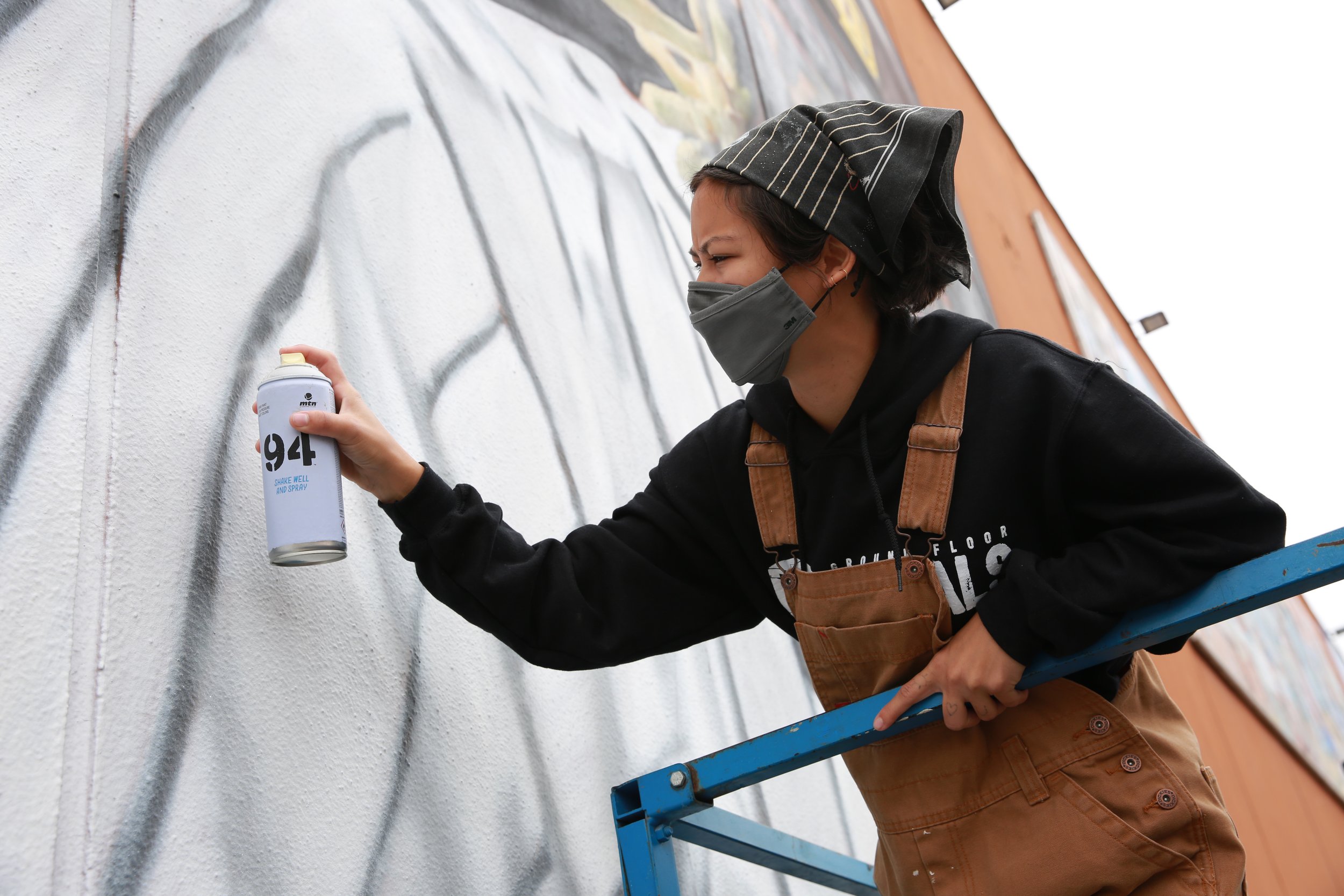Female artist painting the San Diego Padres mural, celebrating local sports culture and community art in San Diego.