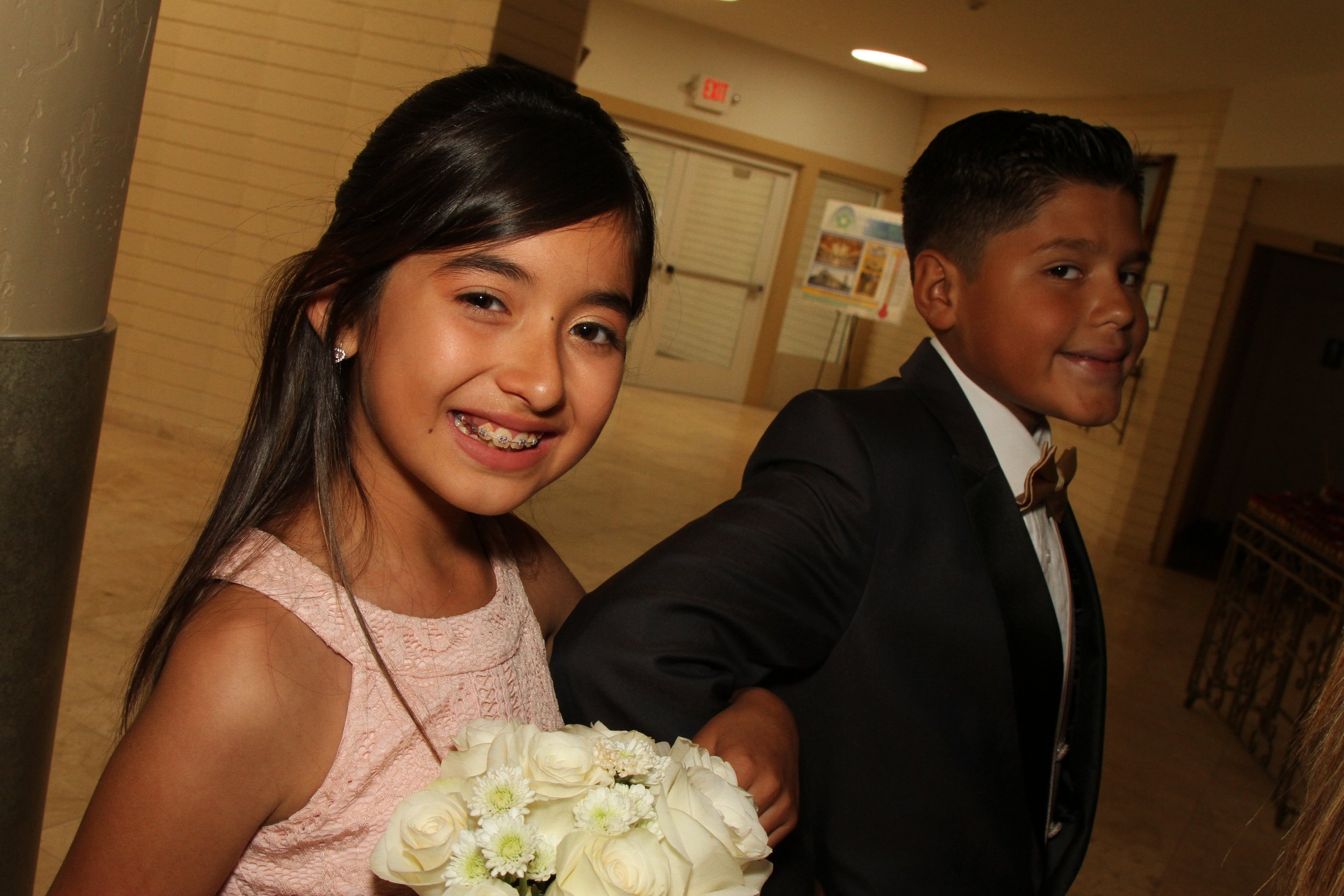 Kids preparing behind the scenes at a Quinceañera event, getting ready for the celebration in San Diego.