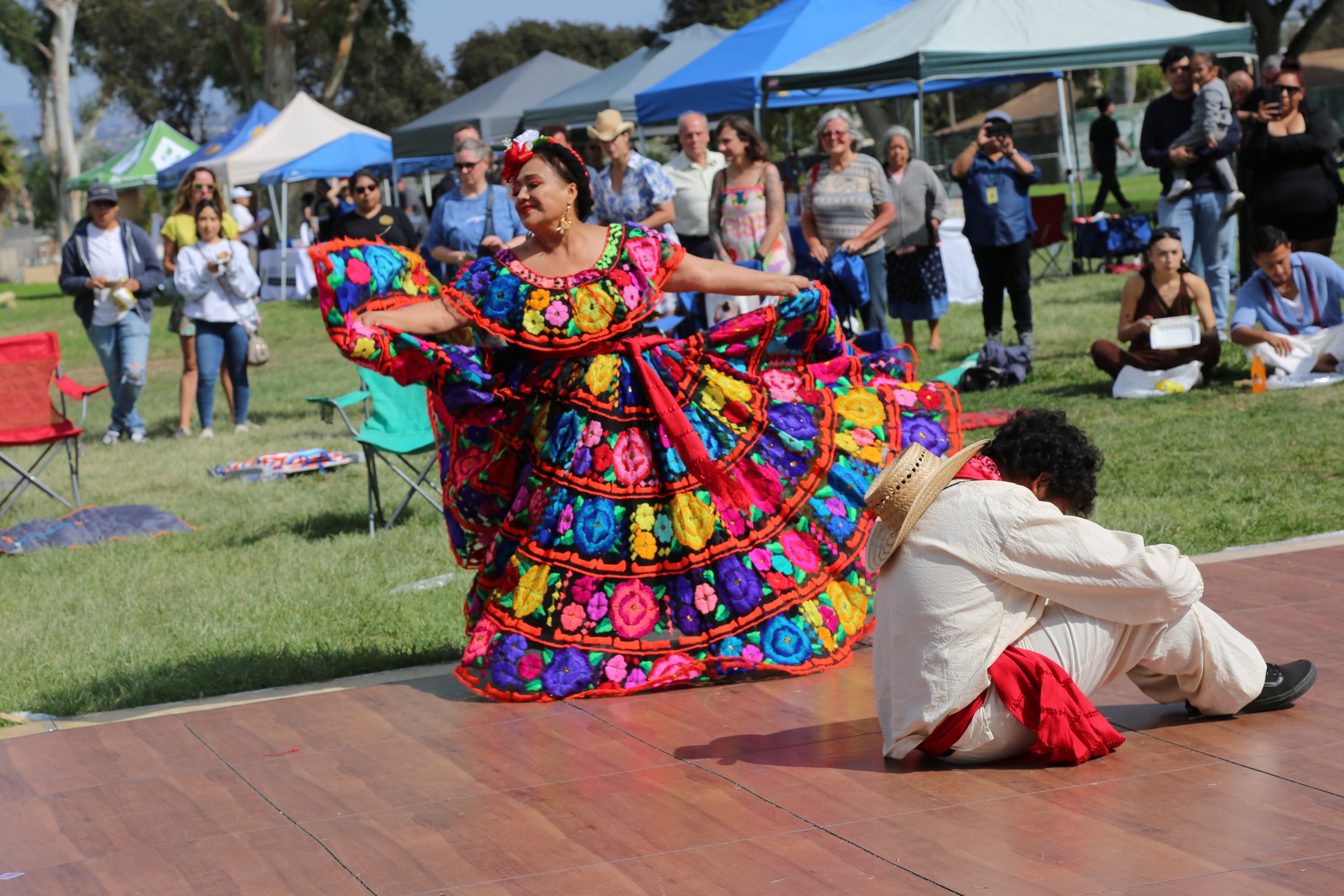 Traditional Latino dancers performing in colorful costumes at a cultural festival in San Diego.