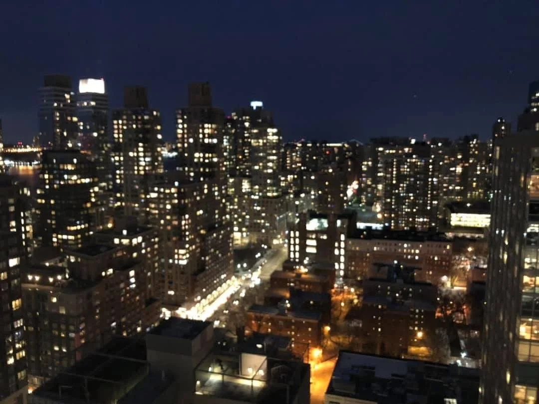 Nighttime cityscape with illuminated high-rise buildings and streets.