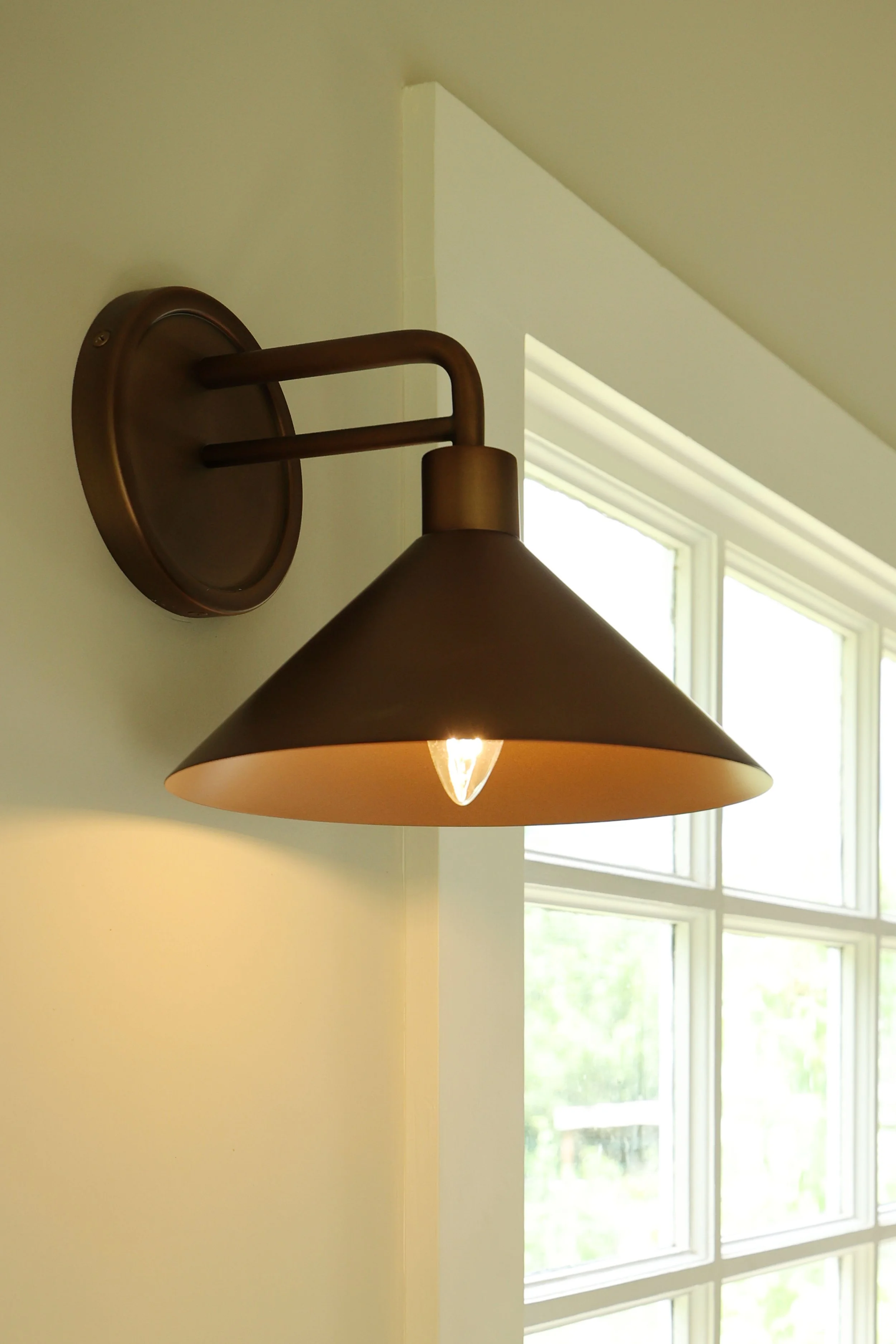 Brass wall sconce lighting detail in a farmhouse mudroom renovation in the Upper Valley.