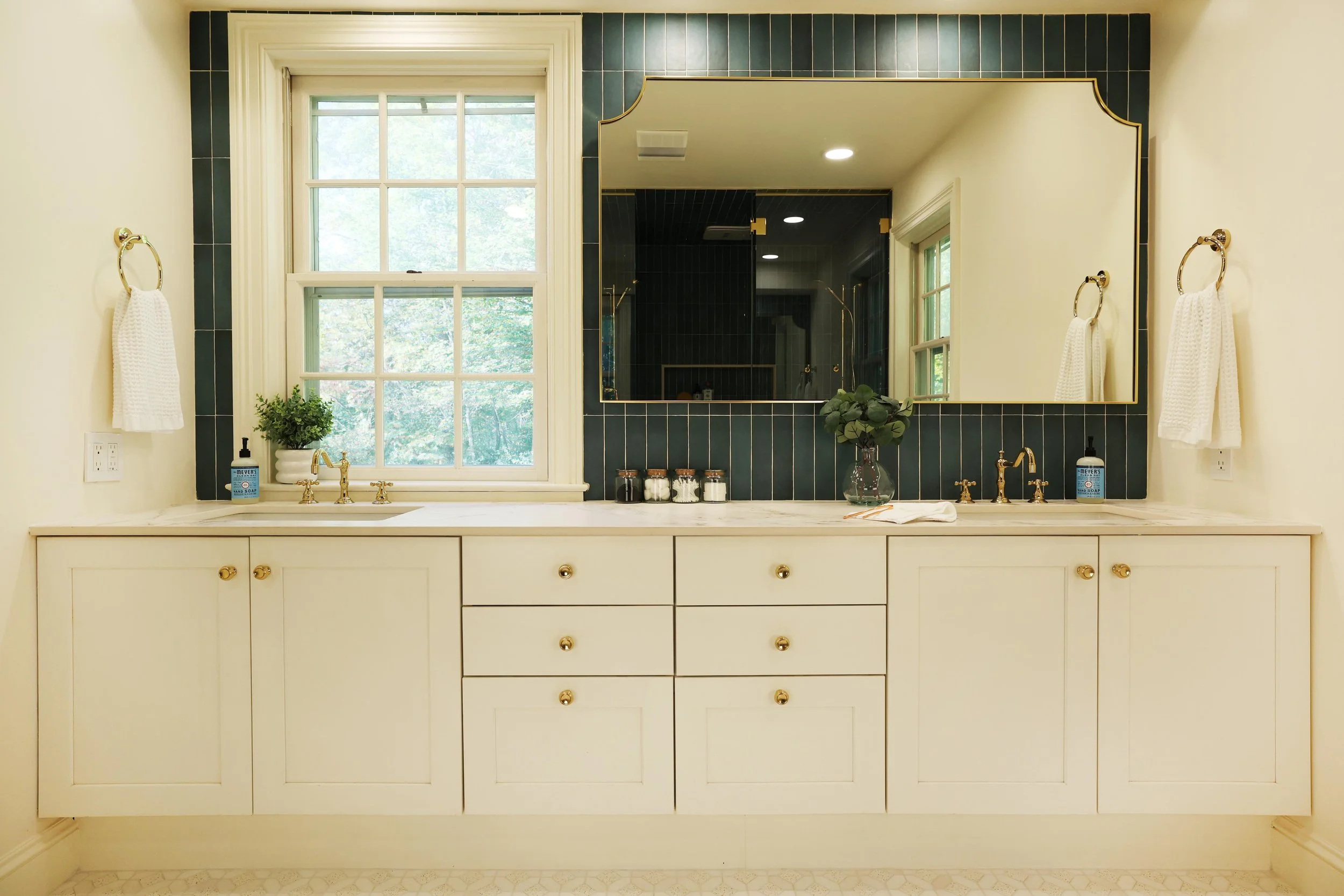 Double cream vanity with marble countertop and brass hardware in Hanover NH primary bathroom