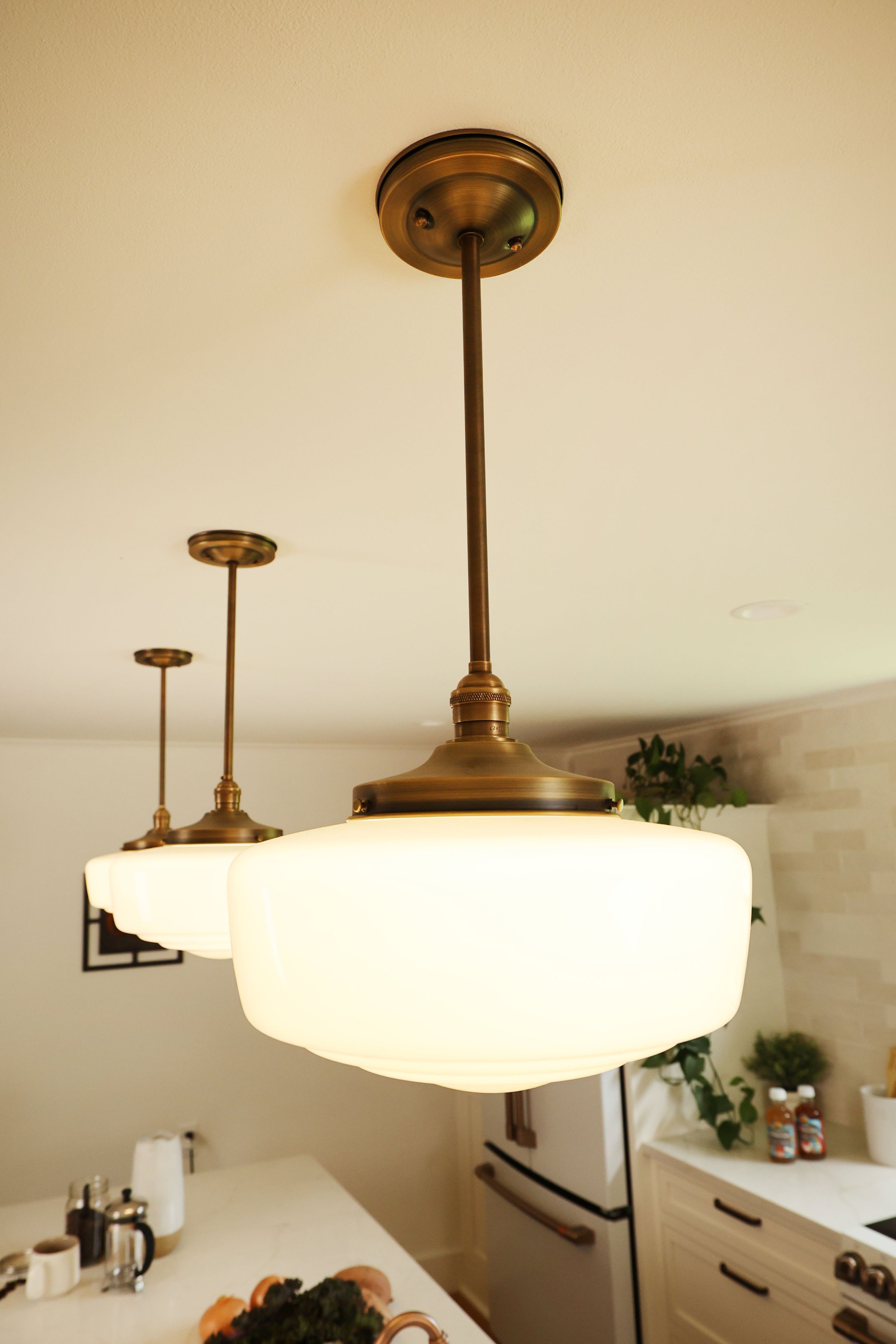 Olde Brick Lighting pendant fixtures in oil-rubbed bronze above the island in a renovated New England farmhouse kitchen.