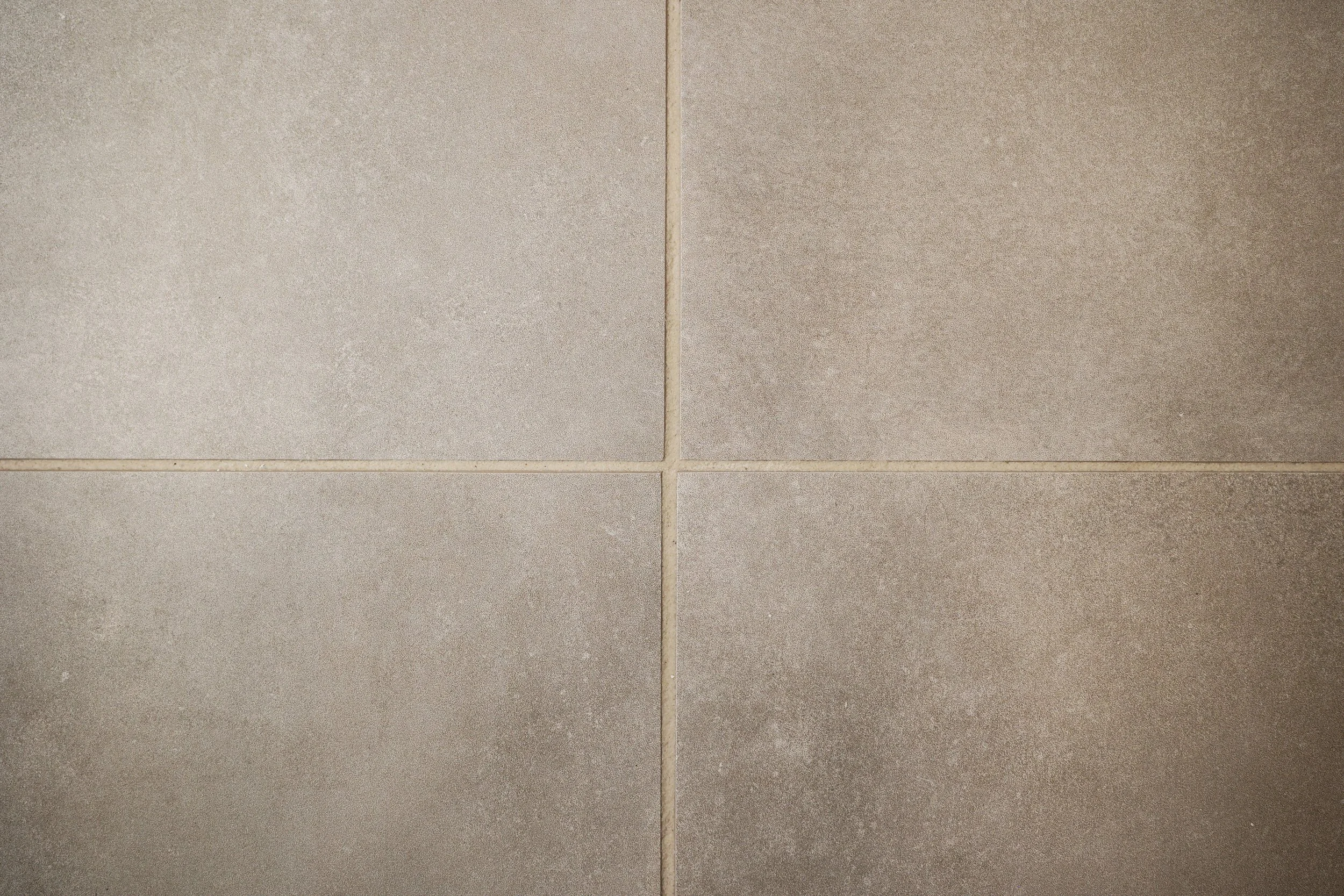Textured neutral bathroom floor tile in a soft, organic modern primary bathroom.