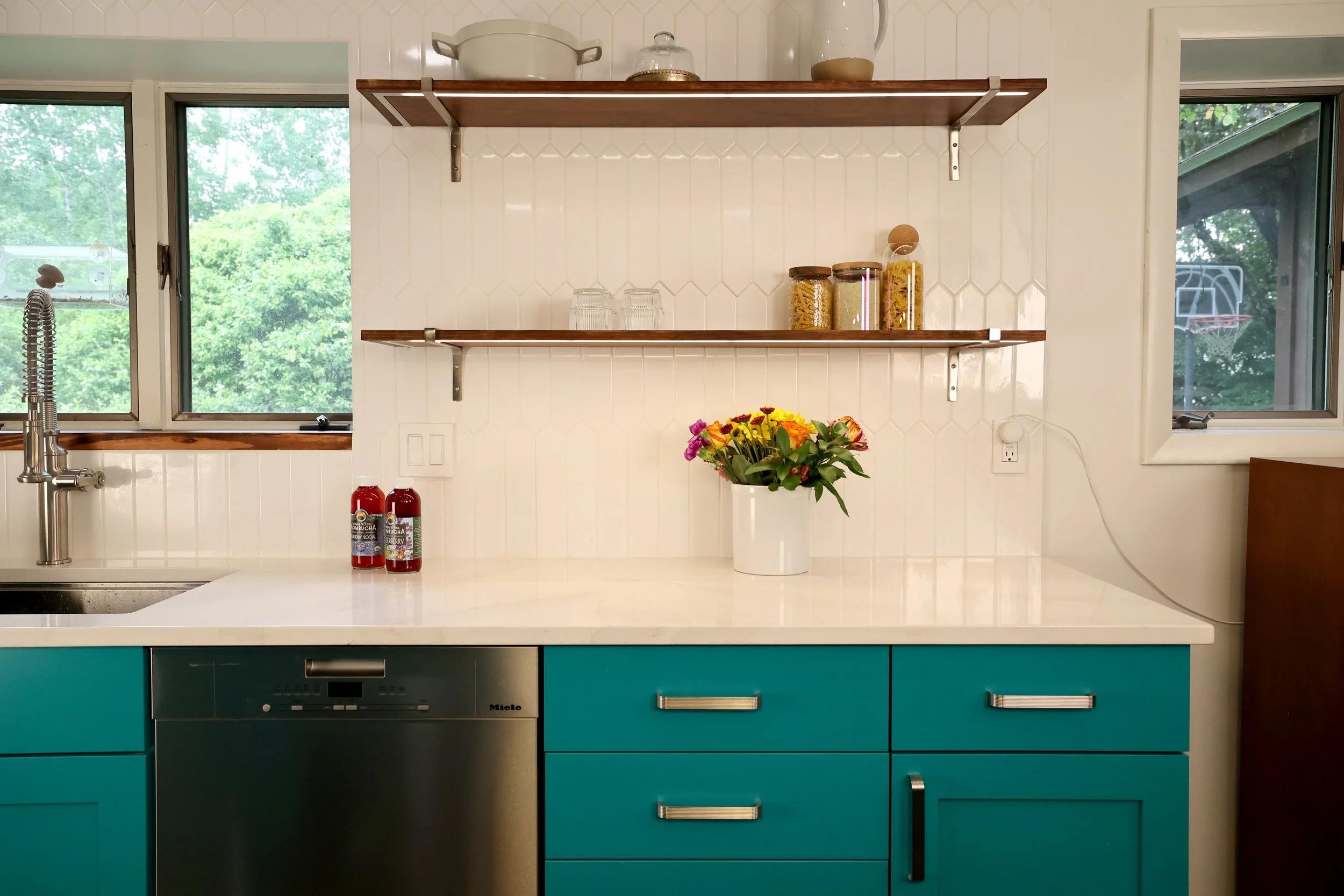 Open kitchen shelving with wood shelf and white backsplash in a White River Junction VT midcentury kitchen.