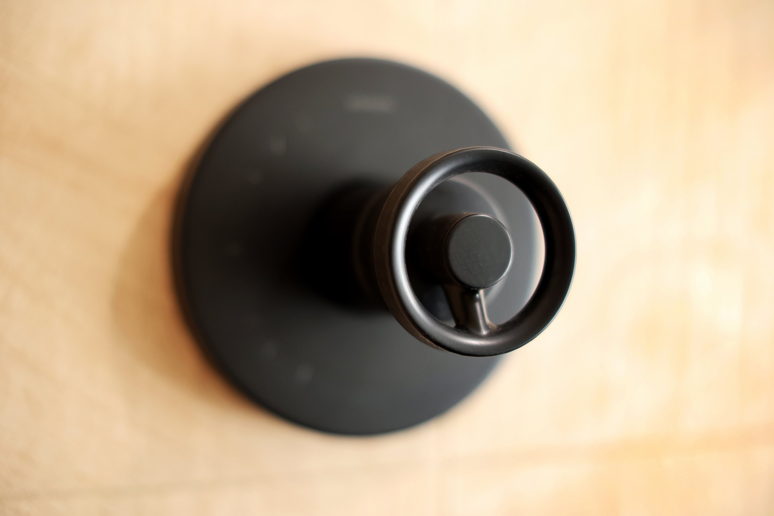 Matte black Kohler shower control detail on wood-look chevron tile in a Burke Vermont ski home bathroom.