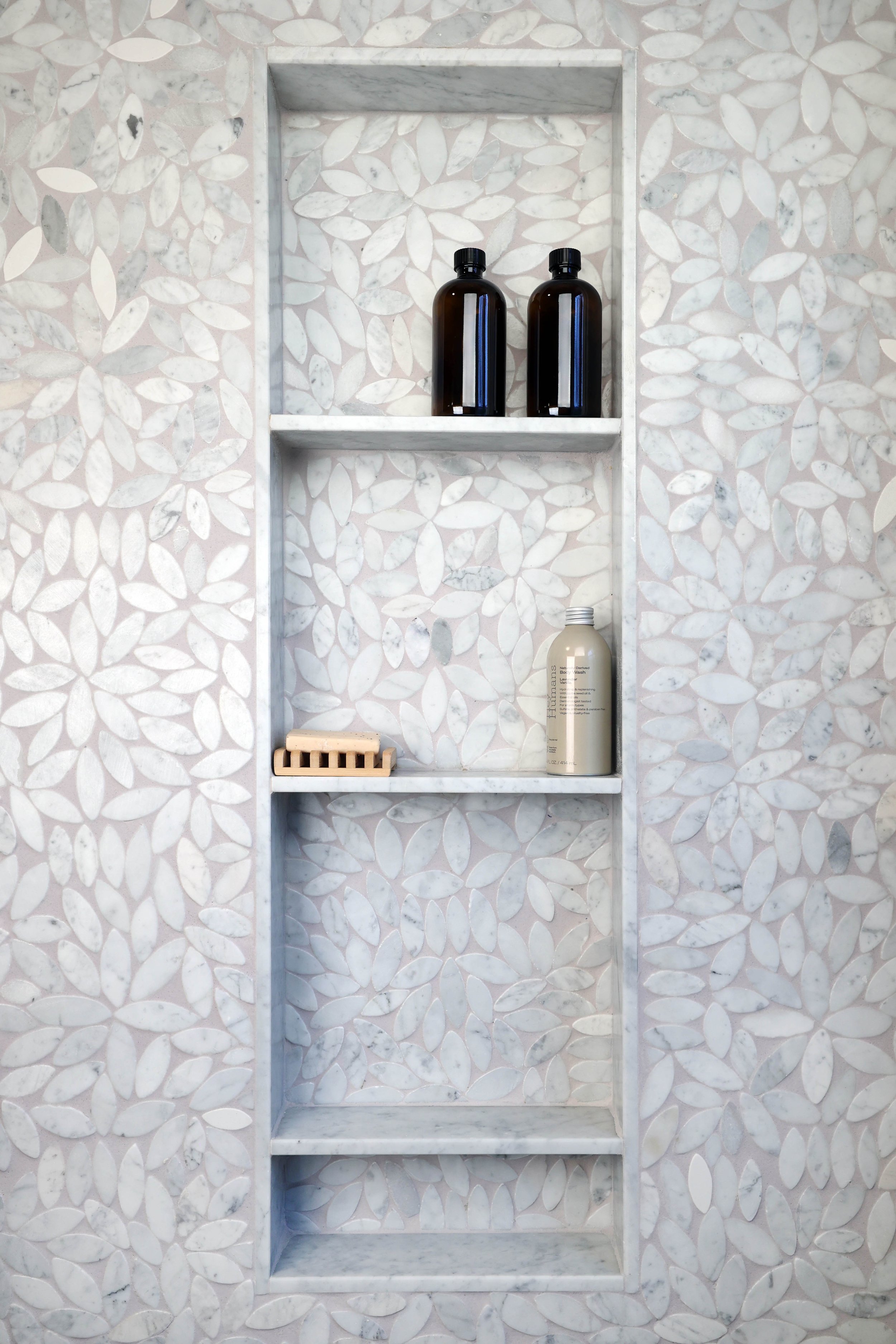 Built-in shower niche with marble tile shelving in historic bathroom renovation.