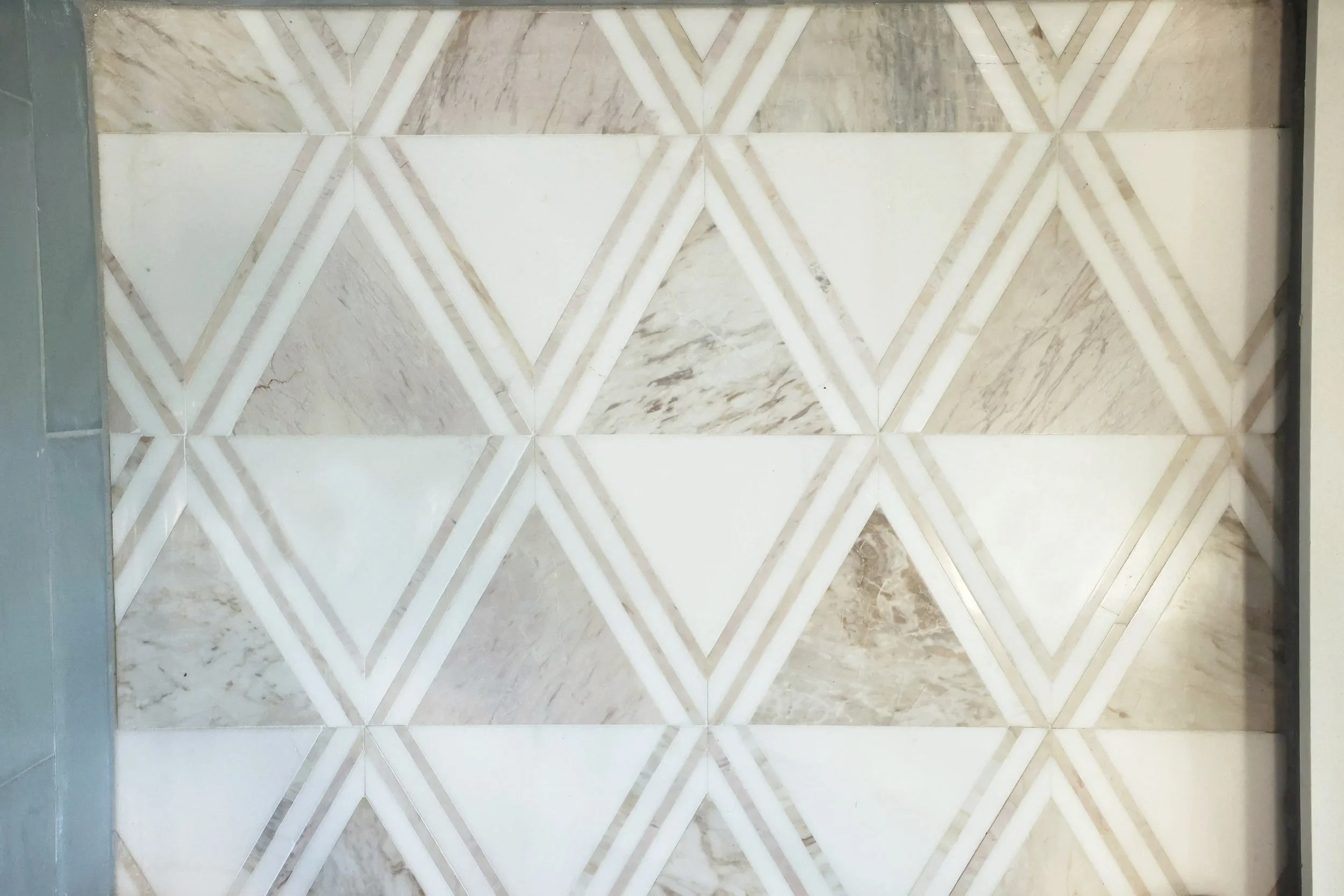 geometric marble tile backsplash installed during New England property renovation to increase resale value