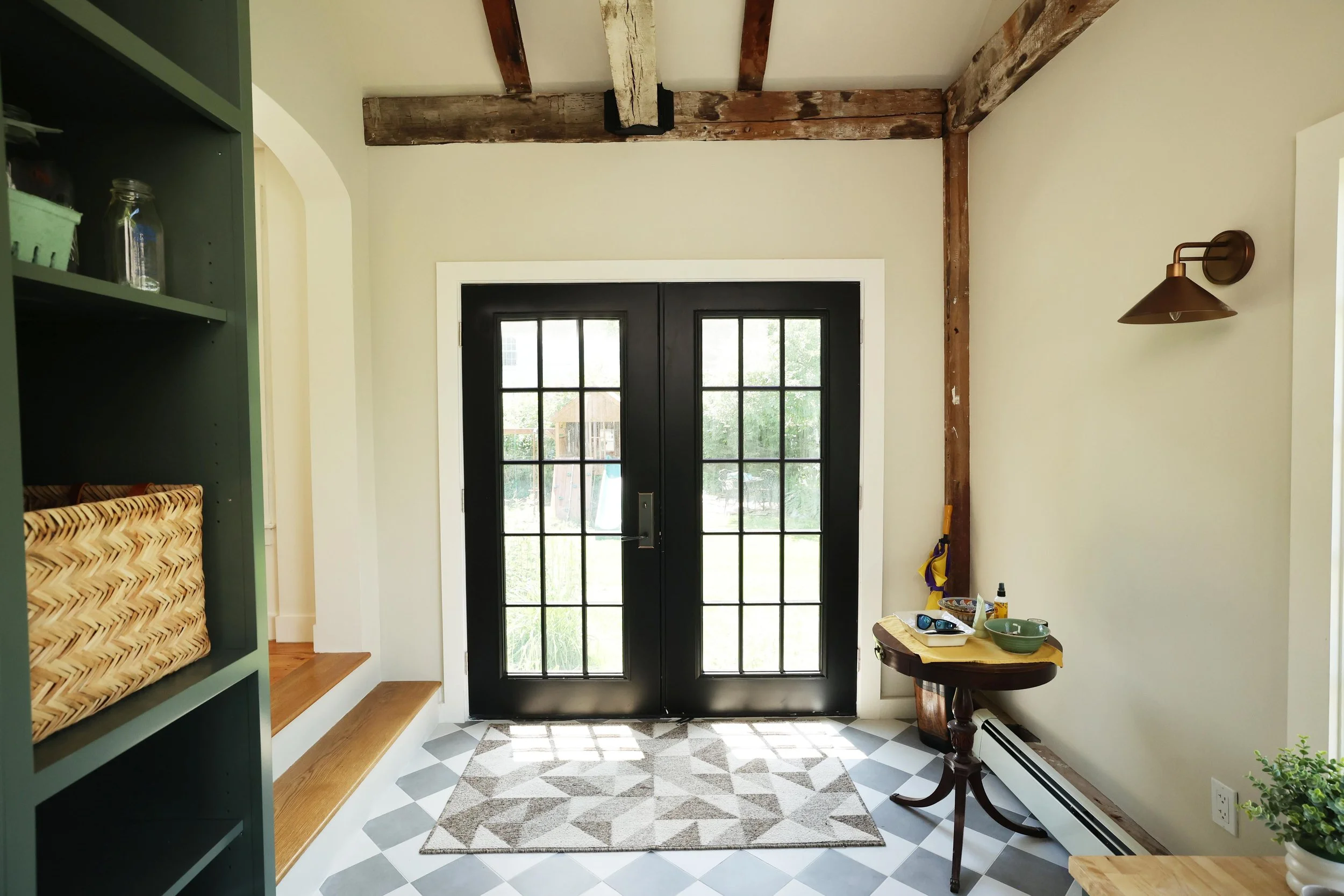 Farmhouse mudroom entry with storage wall of built-in cabinetry in a Thetford Vermont renovation.