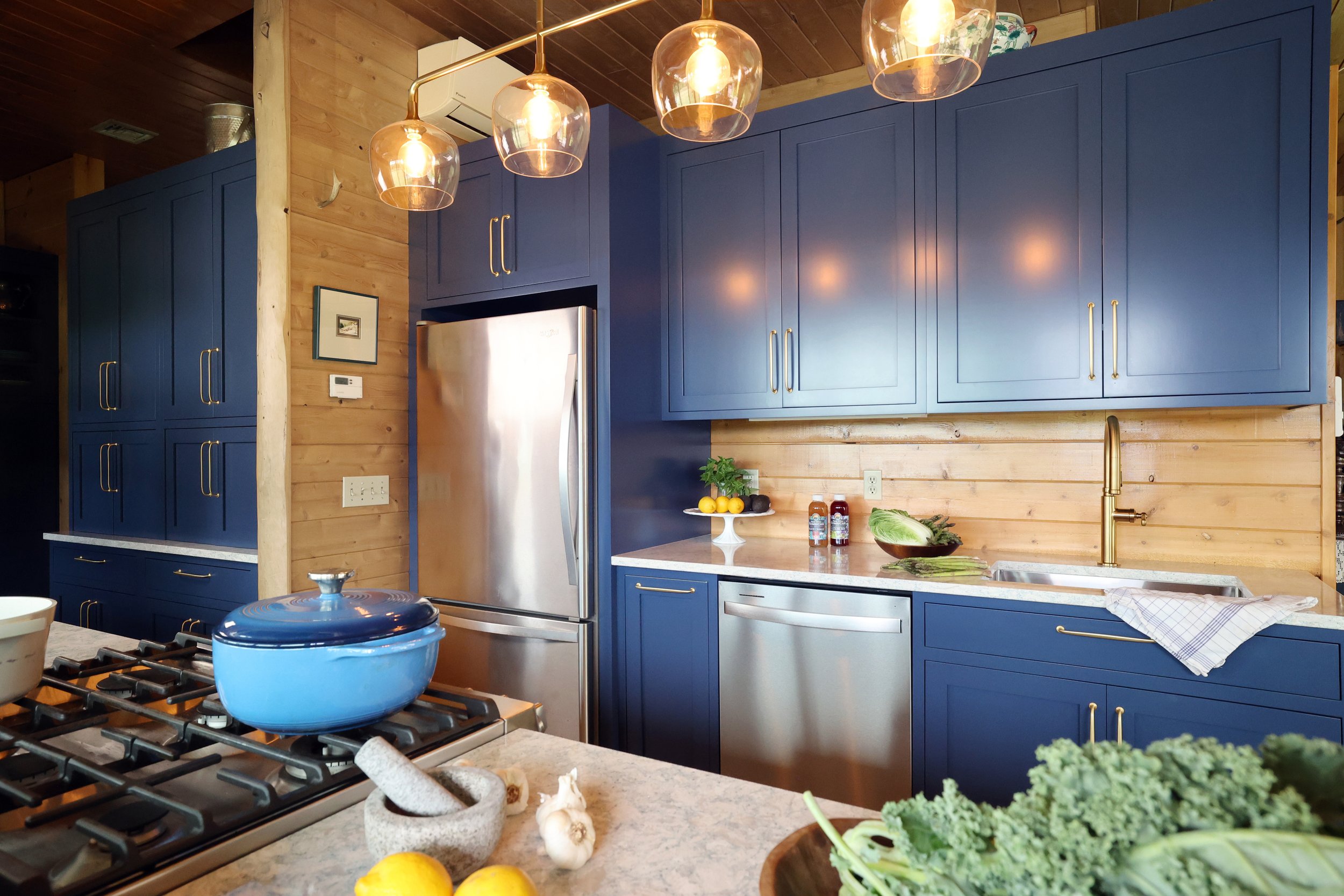 Kitchen appliance wall with custom Crown Point cabinetry in a New Hampshire lodge kitchen.