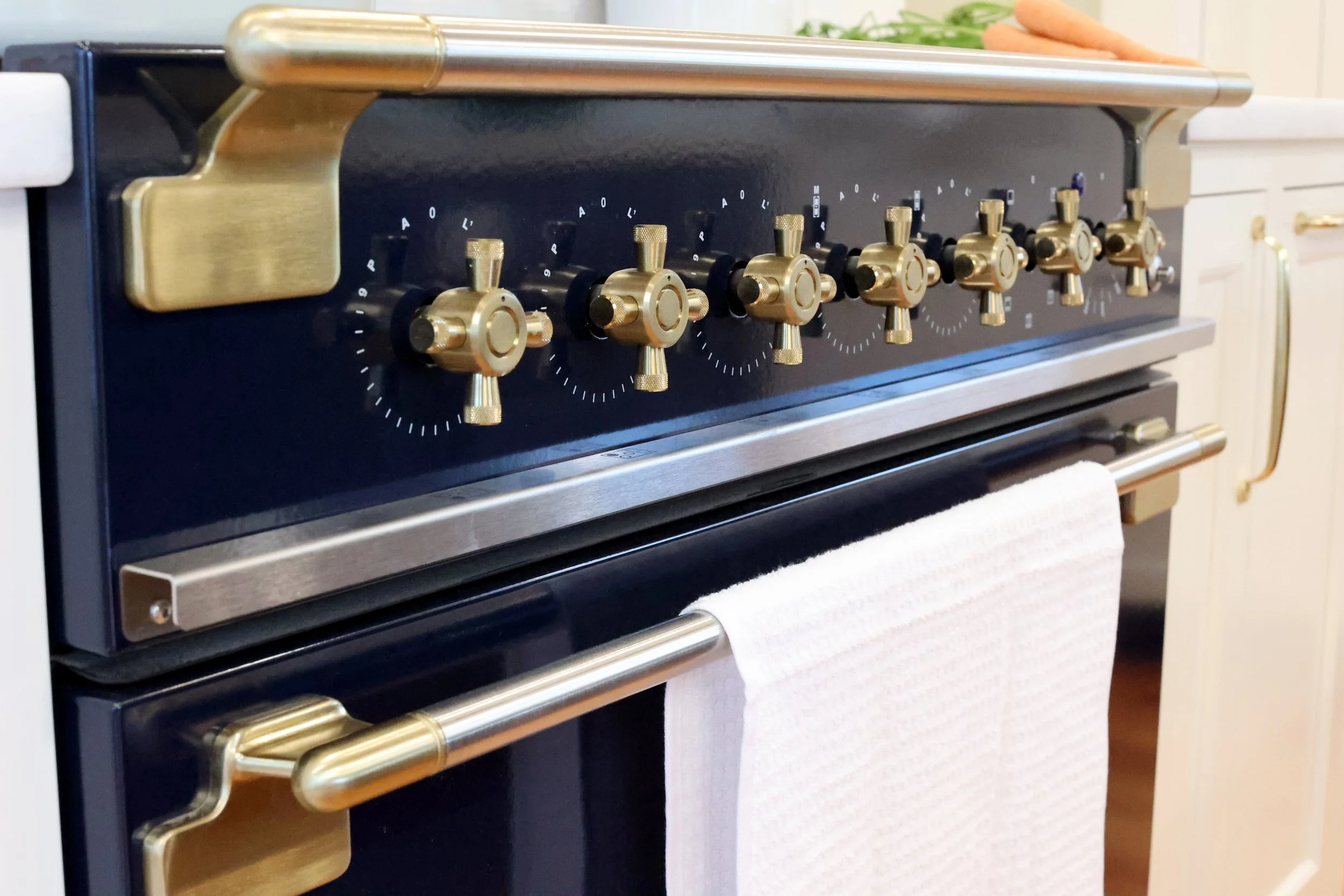 Deep navy AGA range with brass hardware anchoring a traditional Vermont kitchen remodel.