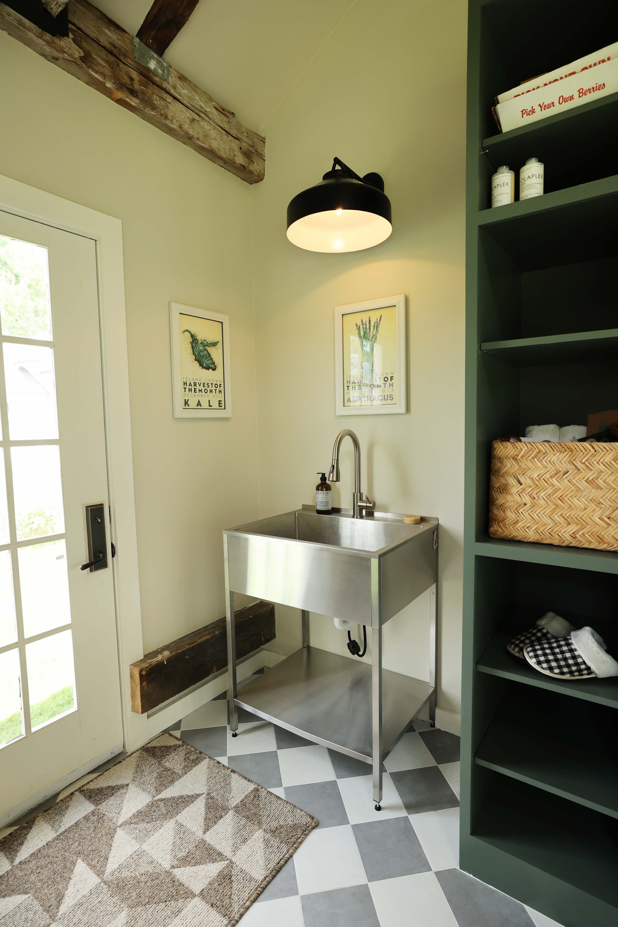 Utility sink and built-in cabinetry creating a practical mudroom workspace.