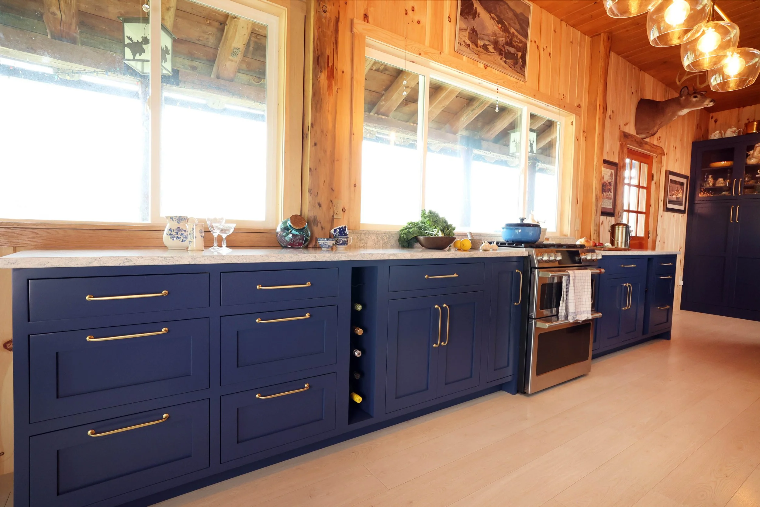 Range wall with Crown Point cabinetry in a rustic New Hampshire lodge kitchen.