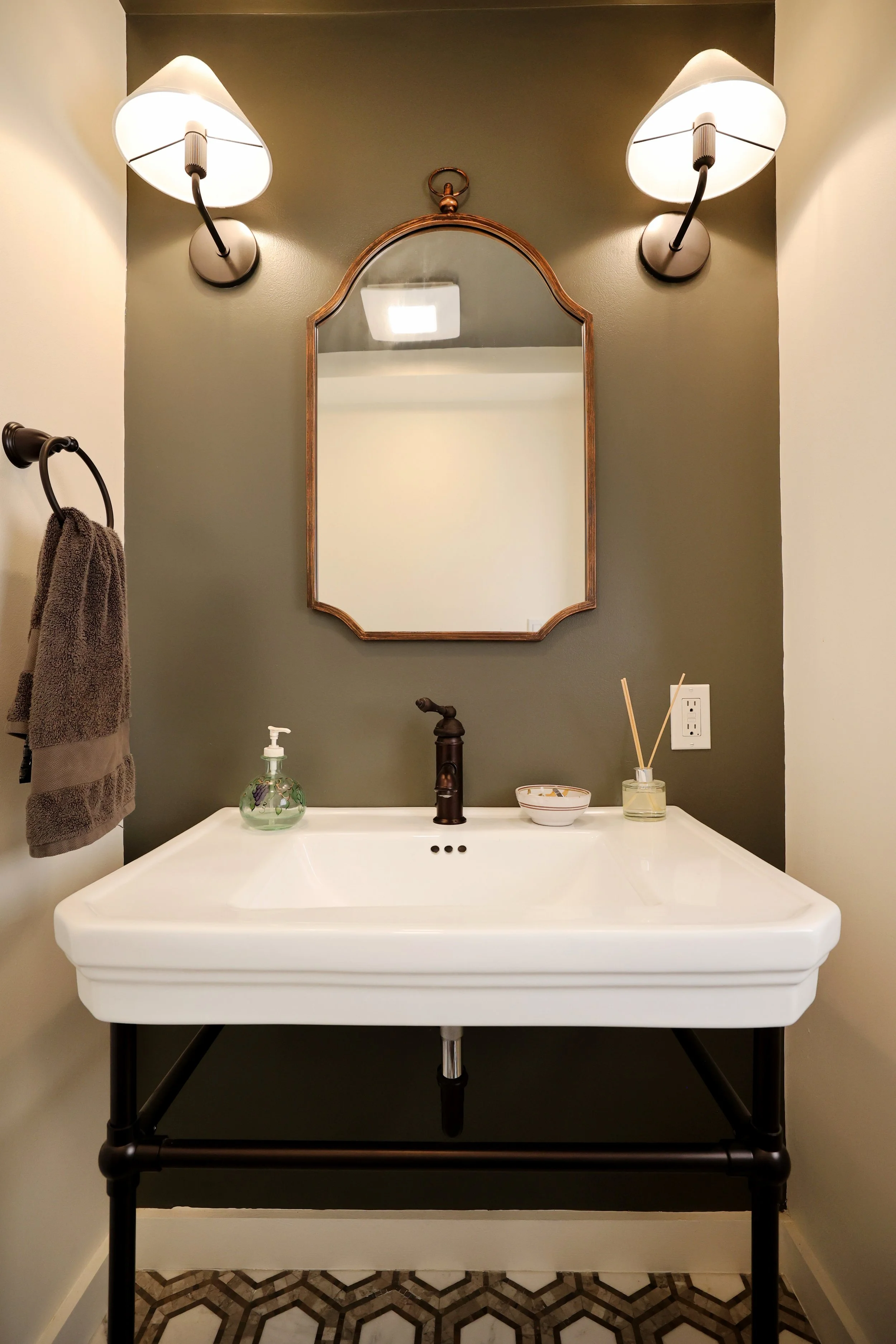Console sink with oil-rubbed bronze faucet and mirror in a classic powder room design.
