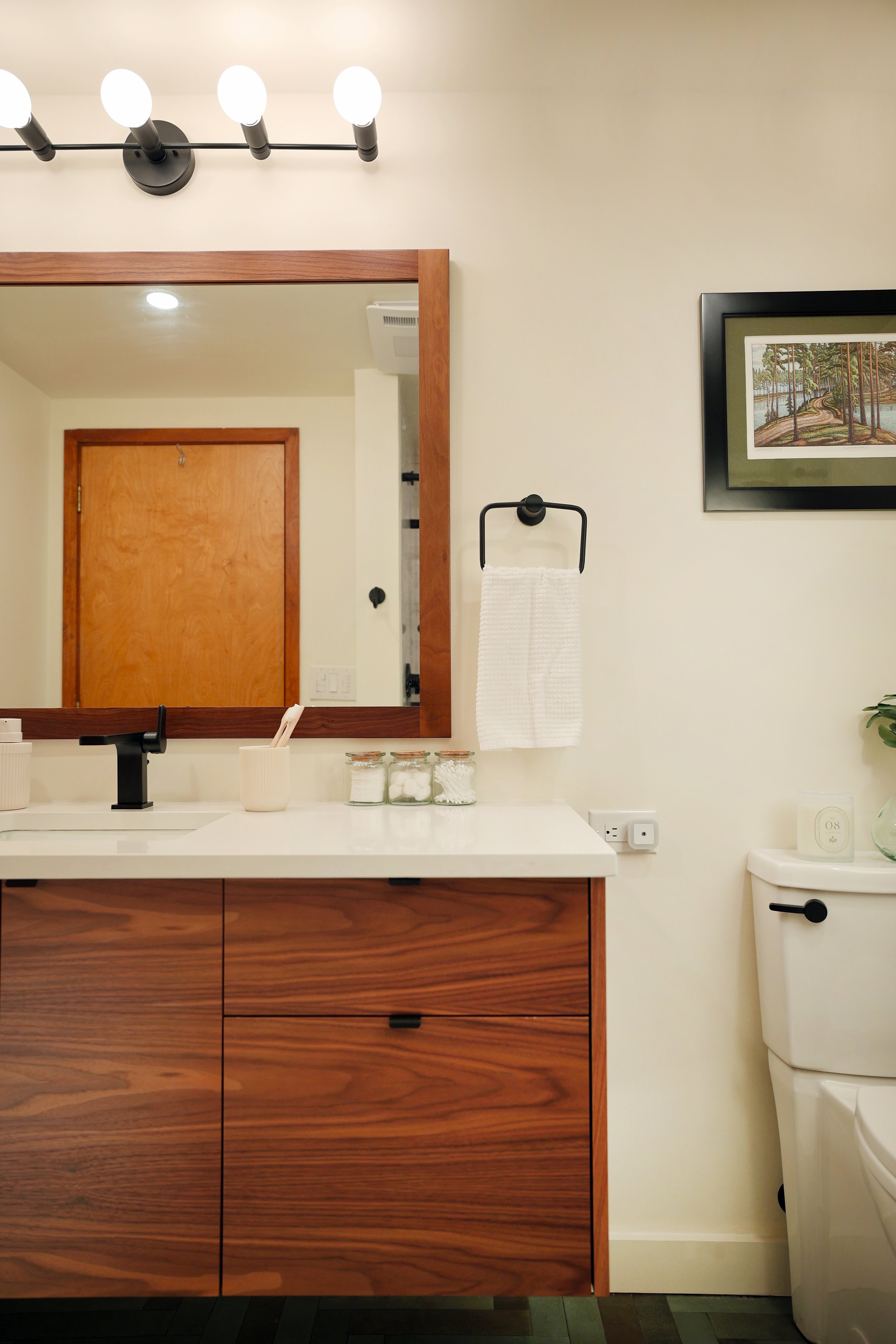 Midcentury bathroom in Hanover NH with walnut floating vanity by Teodor Vanities and matte black faucet.