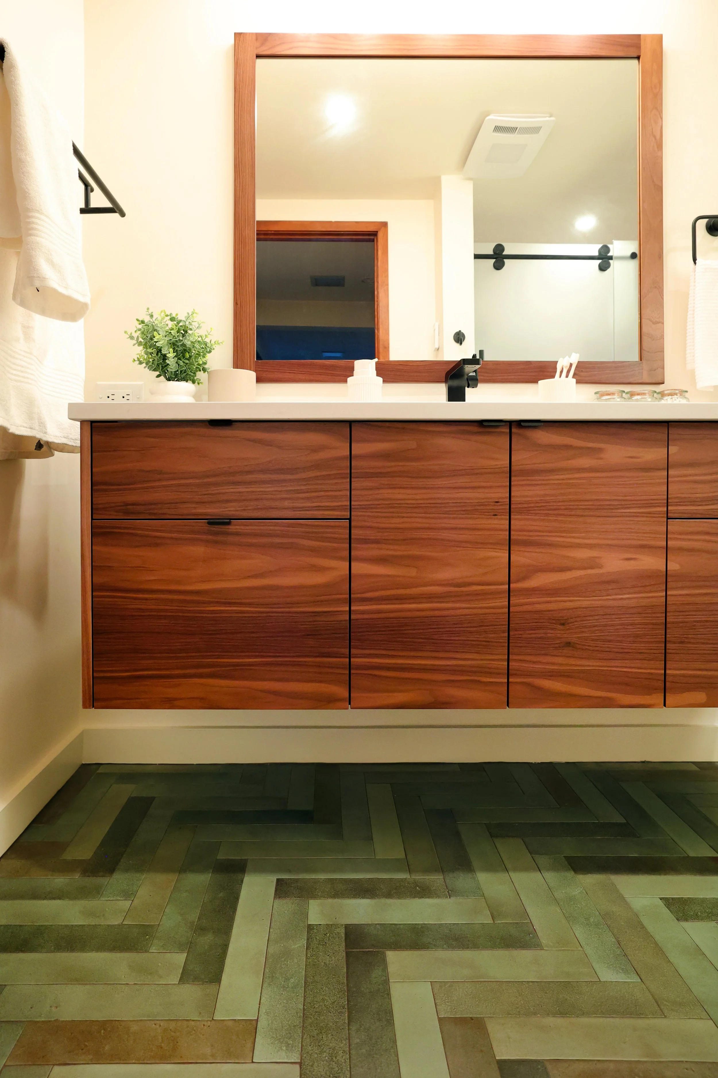 Walnut vanity with integrated pulls and white countertop in a midcentury bathroom in Hanover NH.