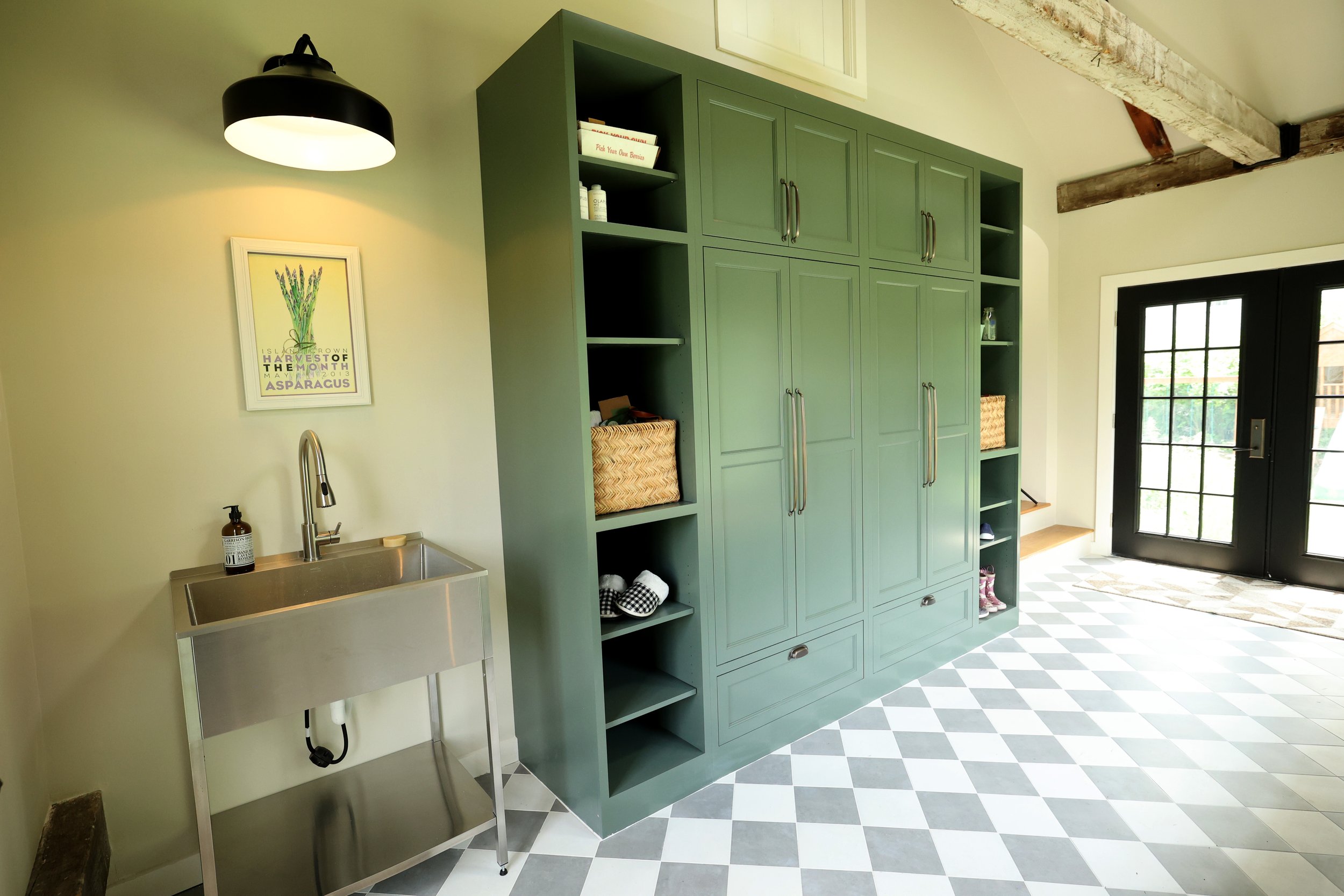 Utility sink and Crown Point cabinetry forming a functional mudroom storage wall.