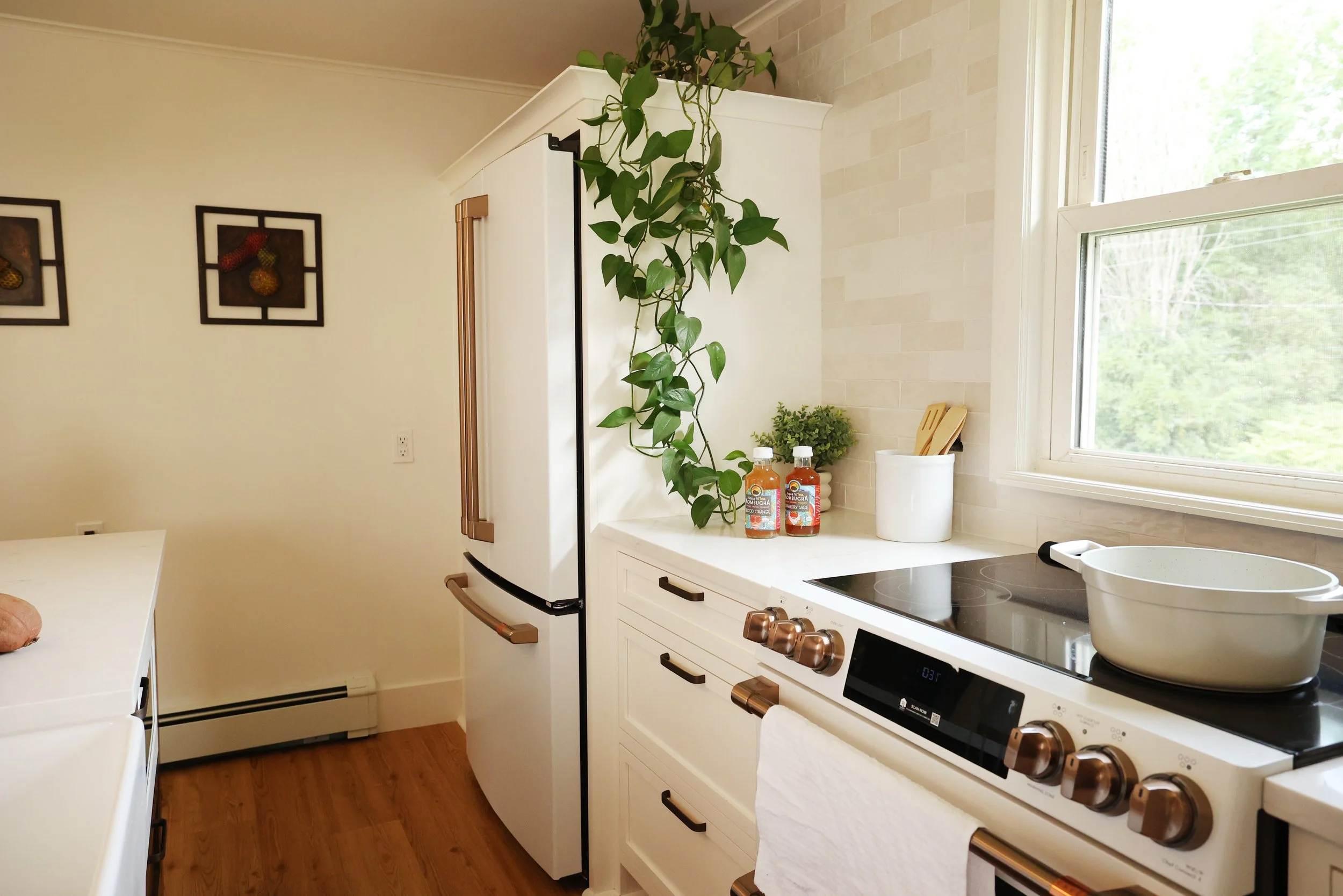 Cream cabinetry surrounding a white range in a historic Bethlehem NH farmhouse kitchen.