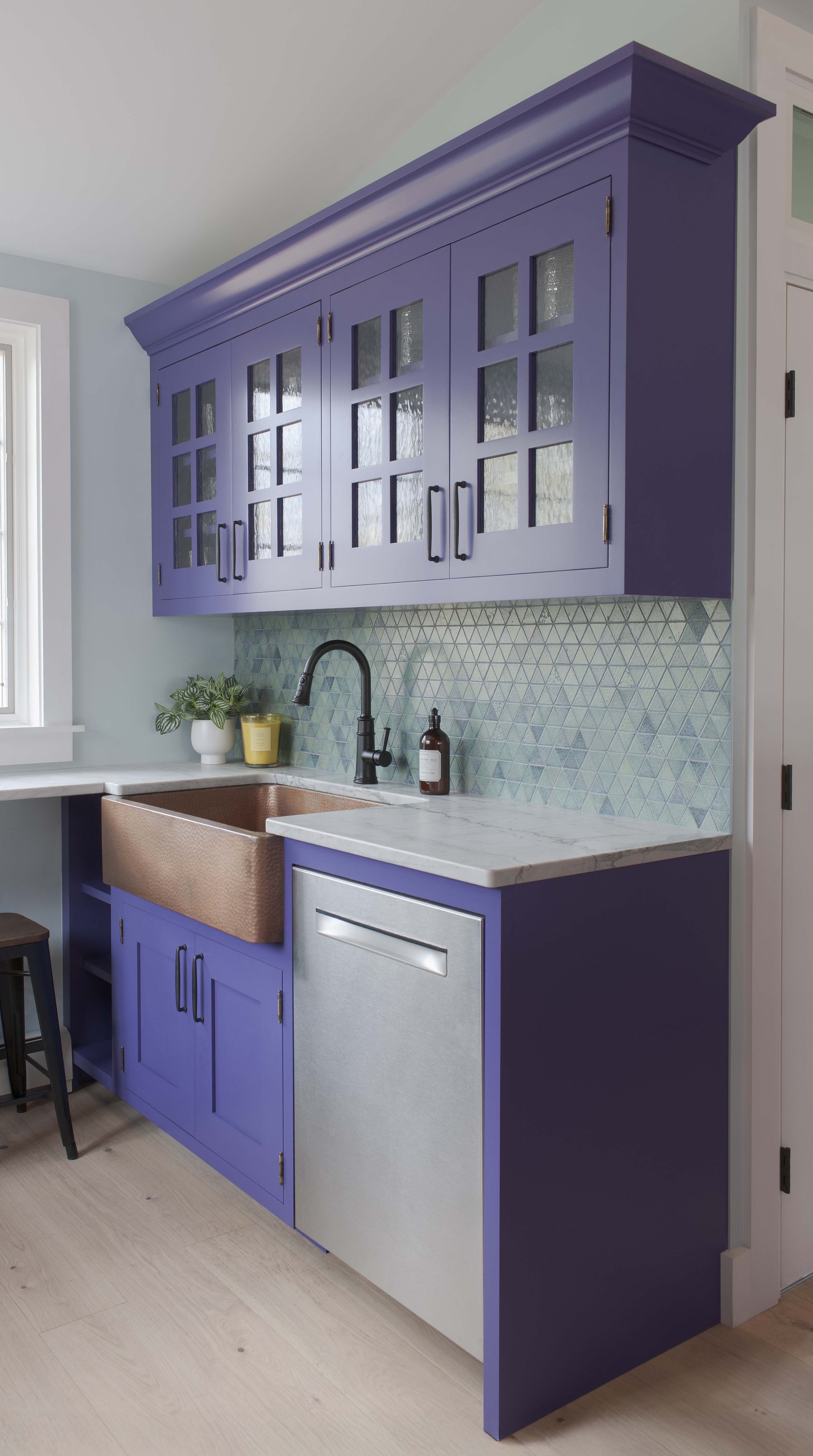 Rejuvenation copper sink set into Maldive Quartzite countertop with Crown Point Cabinetry painted Fully Purple.
