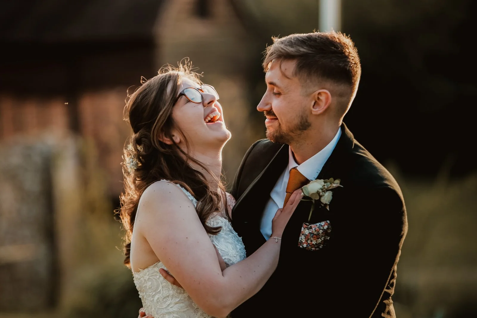 Bride laughing with her groom during relaxed golden hour wedding portraits