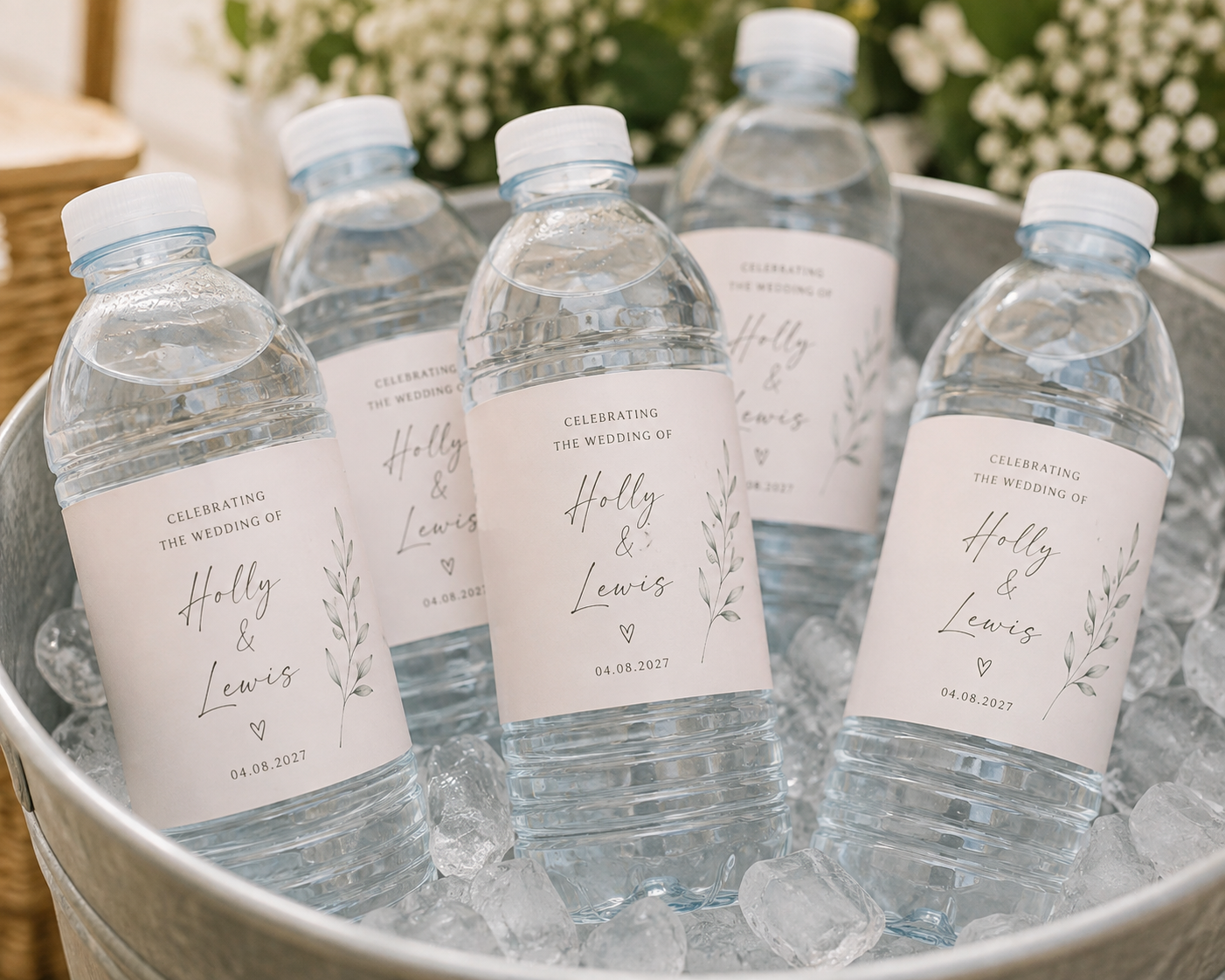 Personalised bottles of chilled water in an ice bucket for guests at a hot summer wedding.