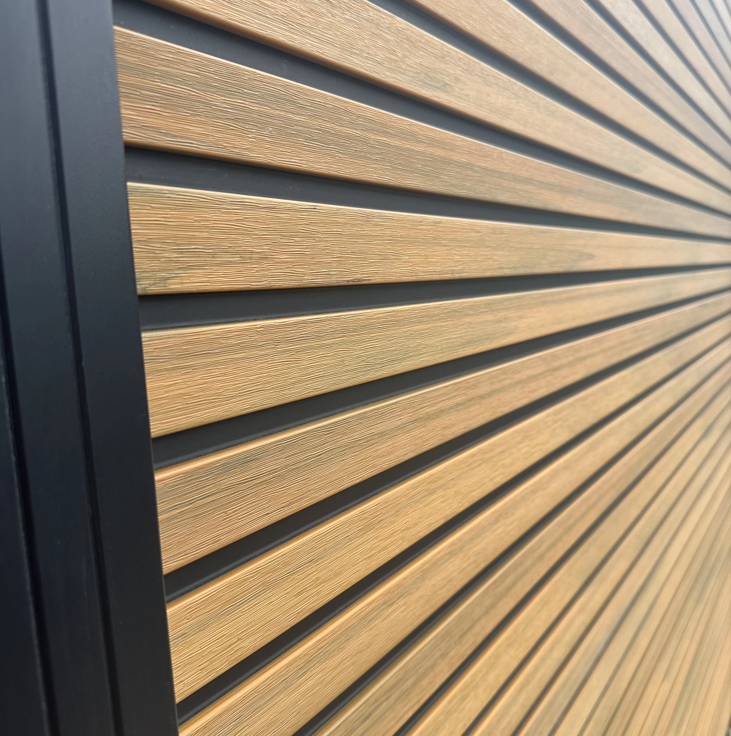 Close-up of a wall with horizontal wooden slats and black metal framing.