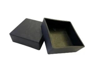 Open black gift box with a gold-lined interior and matching black lid placed beside it.