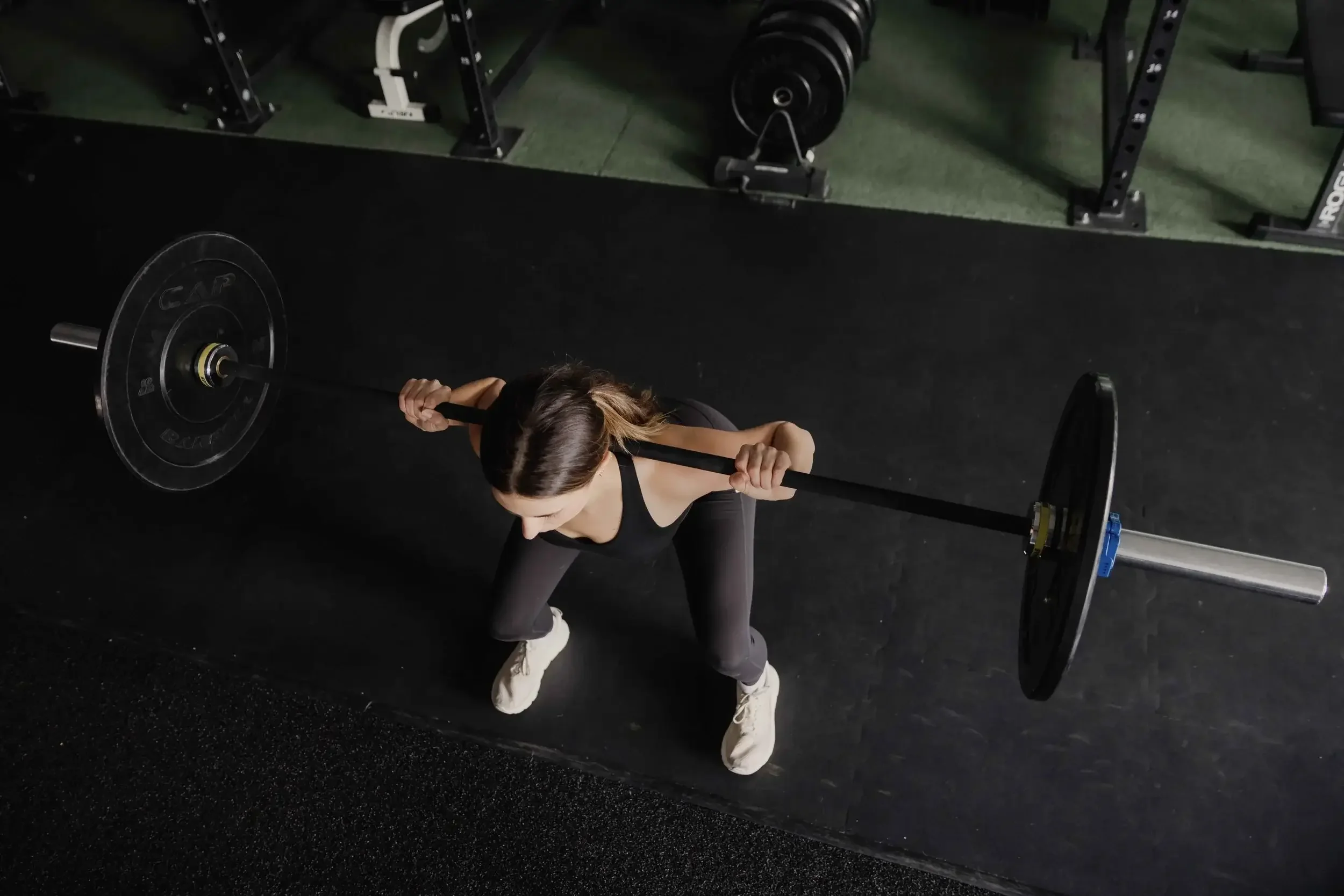 Woman performing a barbell squat in a gym
