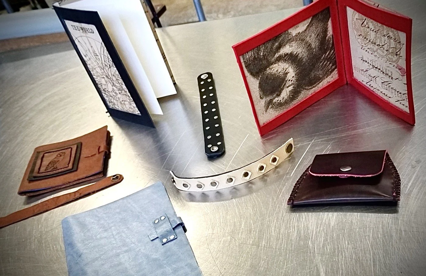 Person operating a vintage-style metalworking tool on a wooden workbench in a workshop setting.