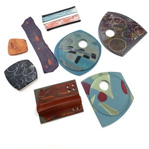 Collection of abstract art glass pieces with various shapes and colorful patterns.