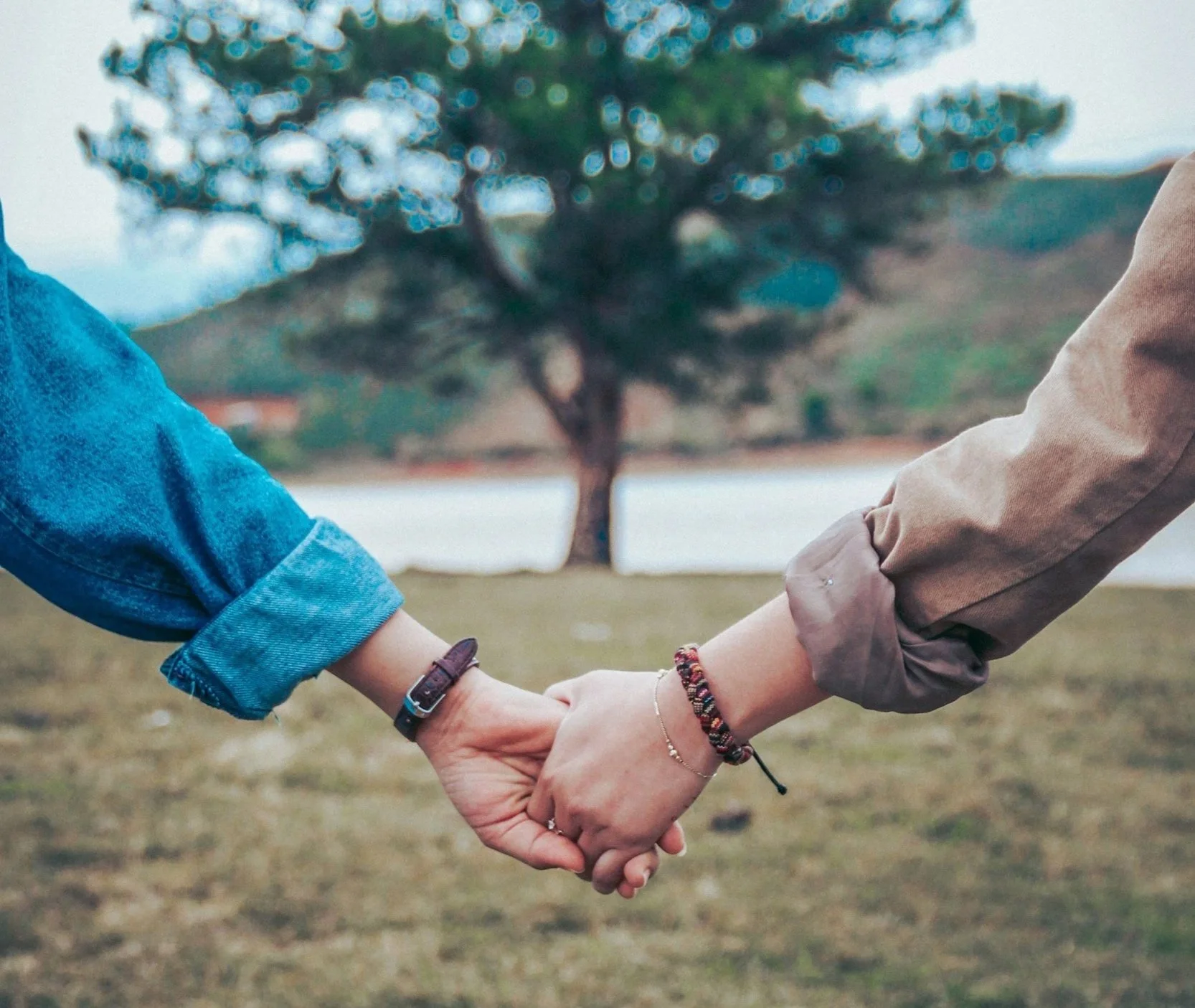 Paar Hand haltend auf einer Wiese | queersensible Paarberatung | Paartherapie | systemische Beratung | psychologische Beratung | Paarcoaching | Kommunikationsskills | Annu Jona Winkler | Berlin online