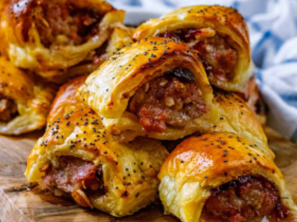 Delicious home made sausage rolls with a golden-brown flaky pastry, sprinkled with black pepper.