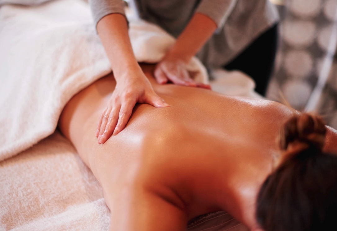 Person receiving a back massage on a massage table in a spa or massage therapy setting.