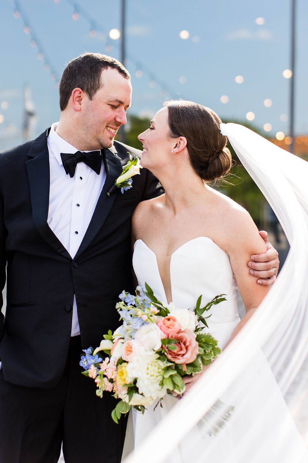 A bride and groom smiling at each other on their wedding day – styled by One Salon & Bridal Co in St. Charles, IL