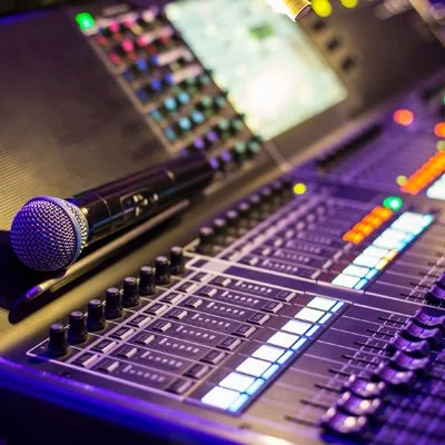 Modern wooden cabin with large window set against a mountainous landscape.