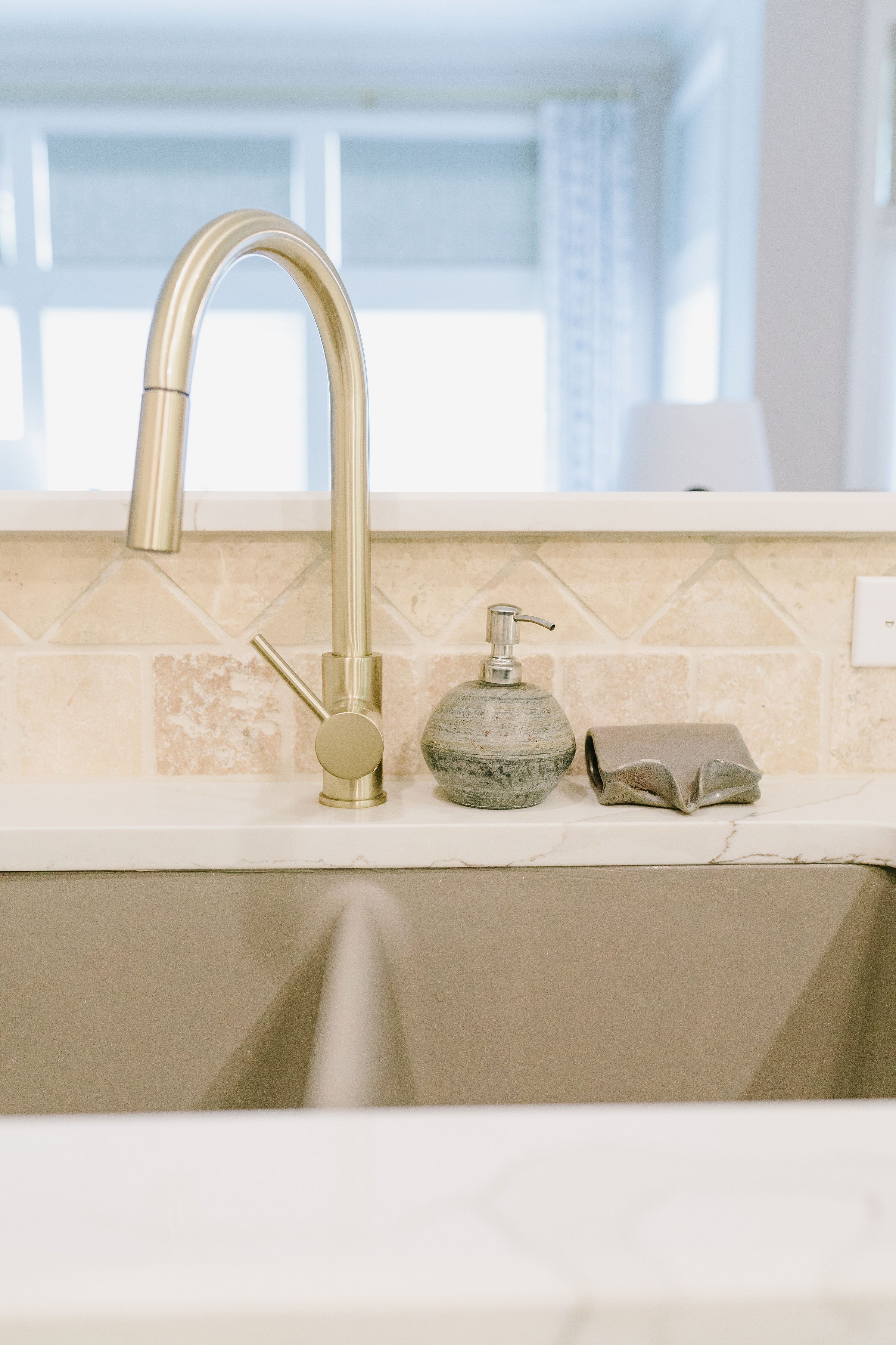 Granite composite undermount double sink with satin gold faucet.