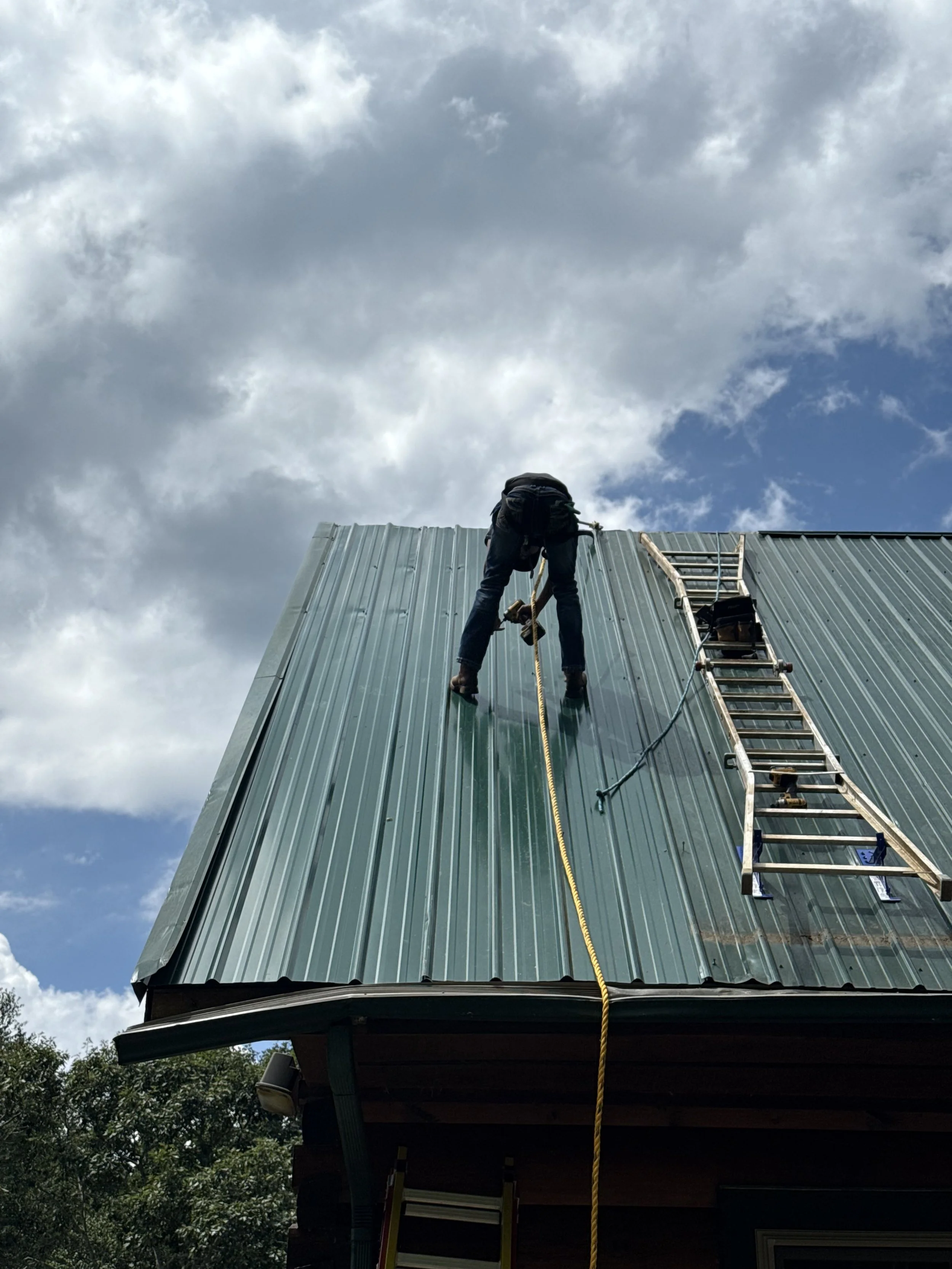 A person is repairing a metal roof for Appalachian Upgrades LLC