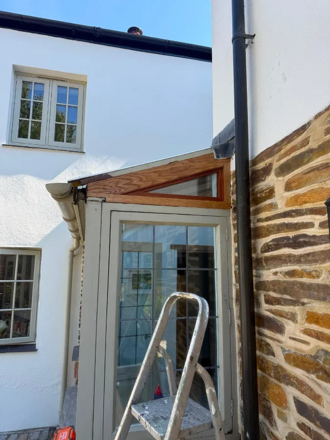 New hardwood porch canopy fitted to a rendered cottage in Truro, beside exposed Cornish stone