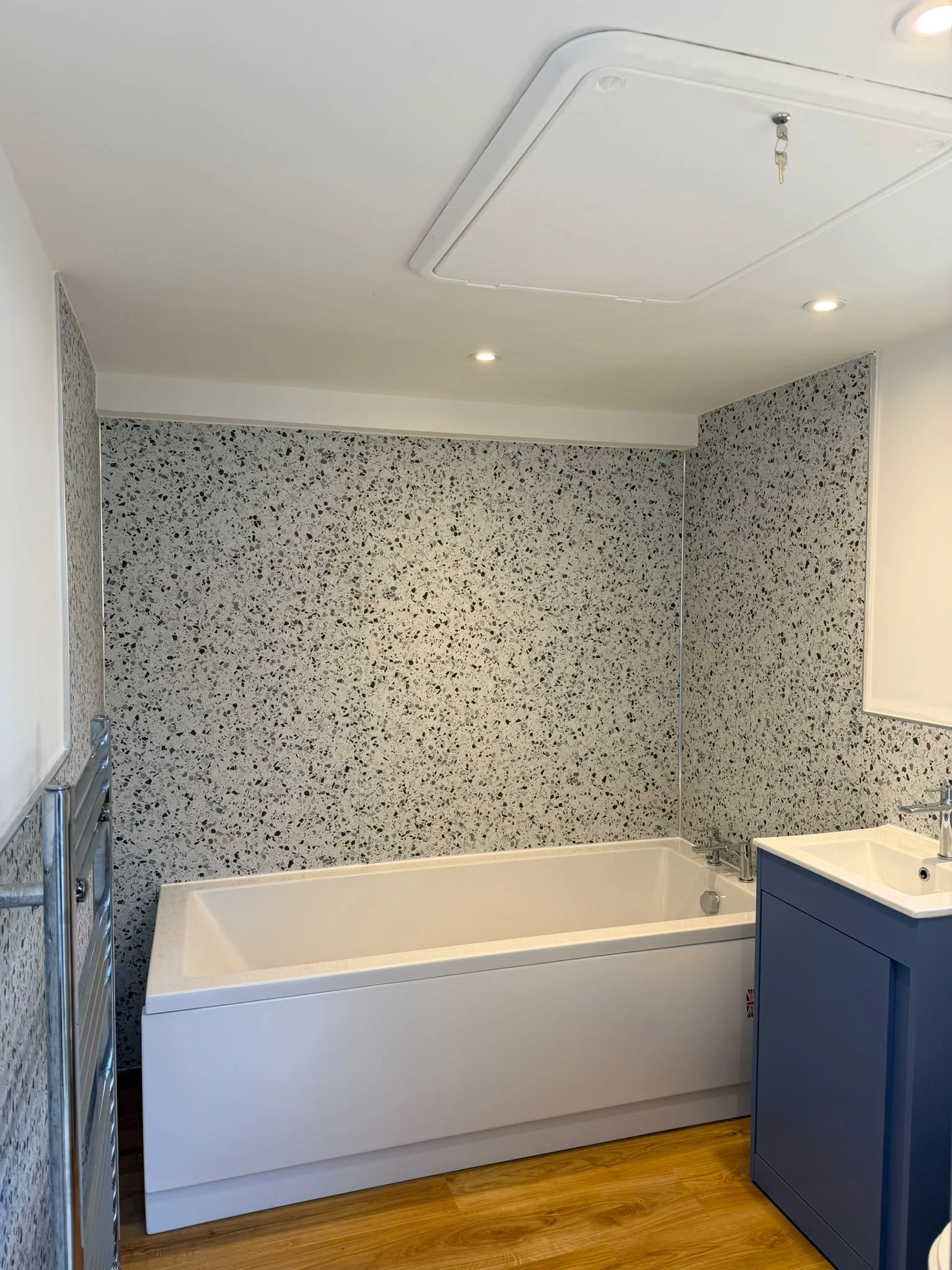 Newly fitted bathroom with bath, vanity unit and wood flooring, St Austell