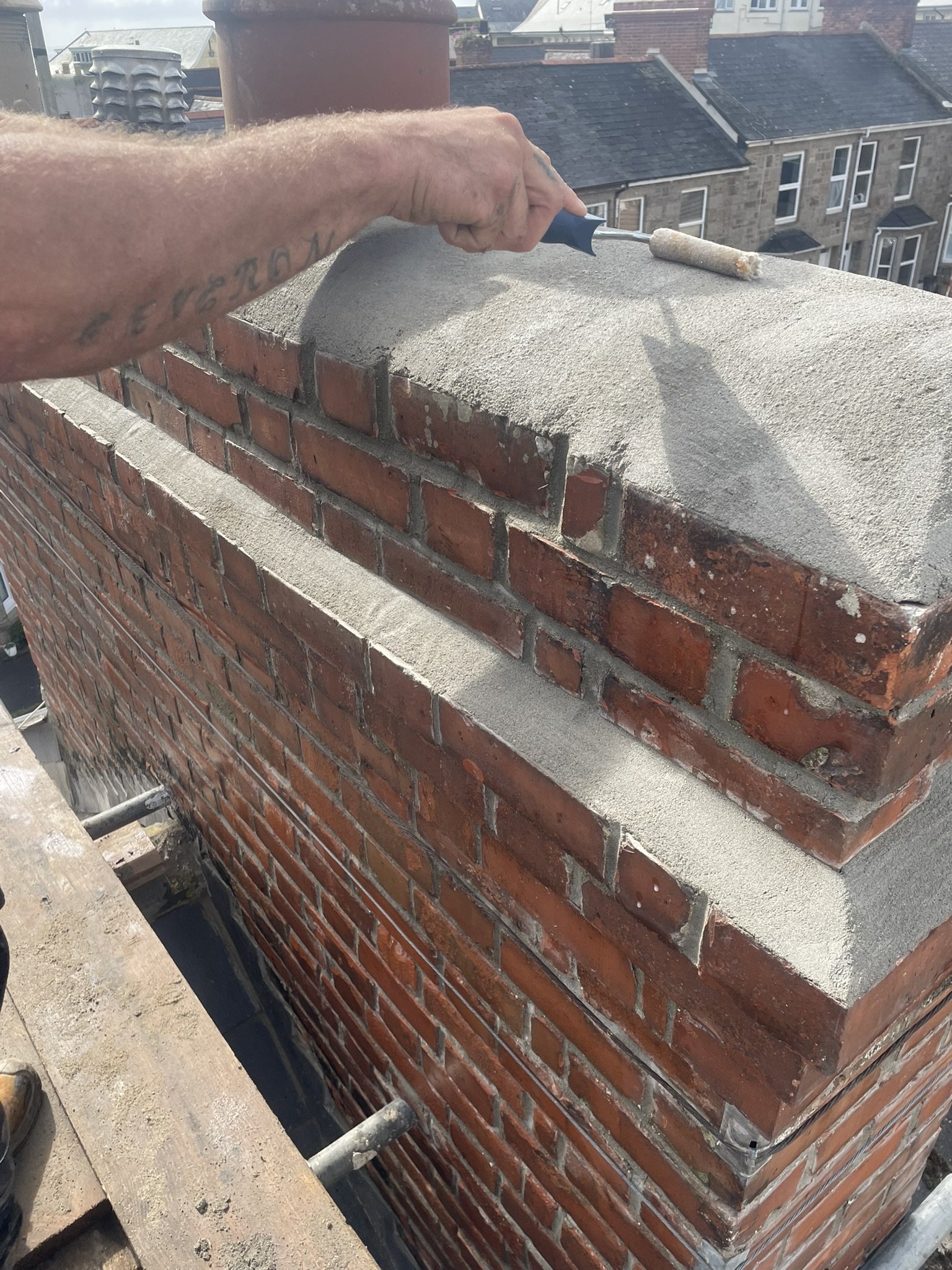 Chimney waterproofing being applied during a reactive roof repair in Cornwall