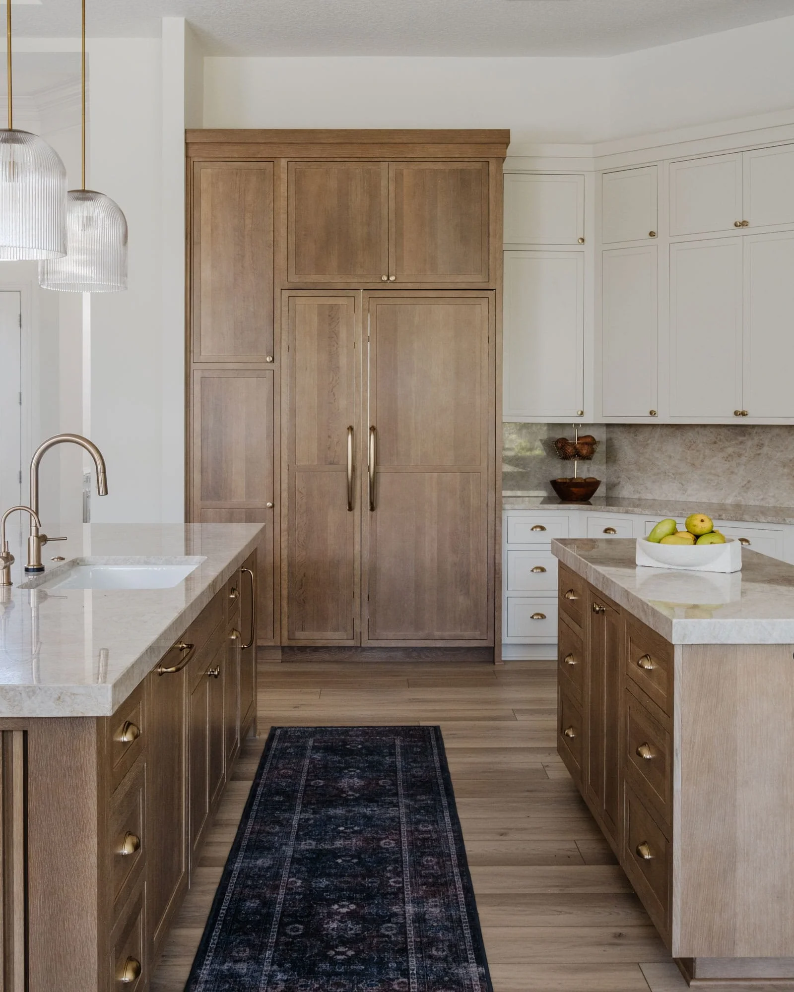 A luxury kitchen featuring a tasteful mix of stained wood and eggshell paint cabinetry.