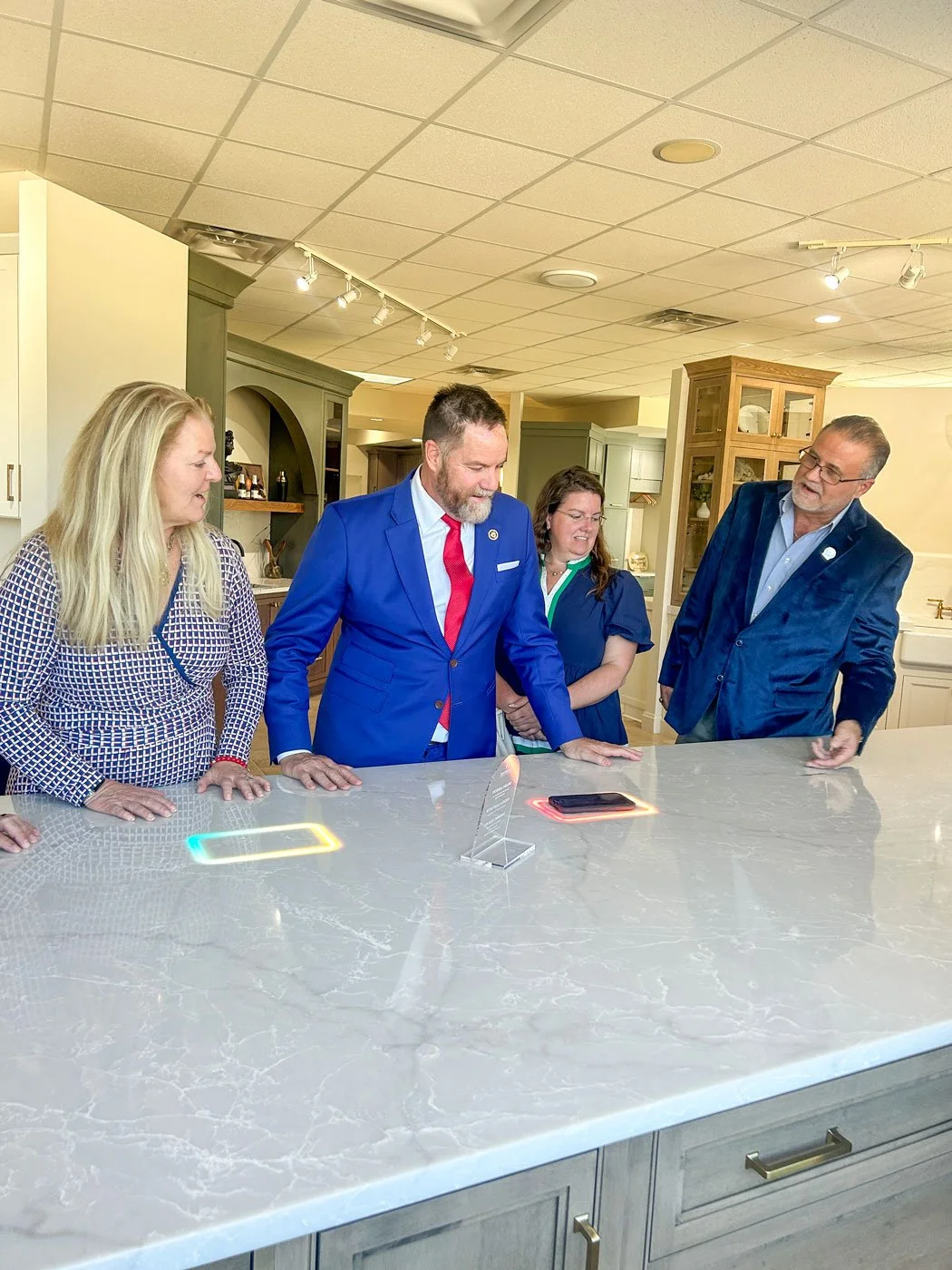 Woodsman President Brad Mangold demonstrates FreePower wireless charging to Congressman Aaron Bean, His wife Abby, and Mr. Bean's Special Projects Coordinator Perét in the Woodsman showroom.
