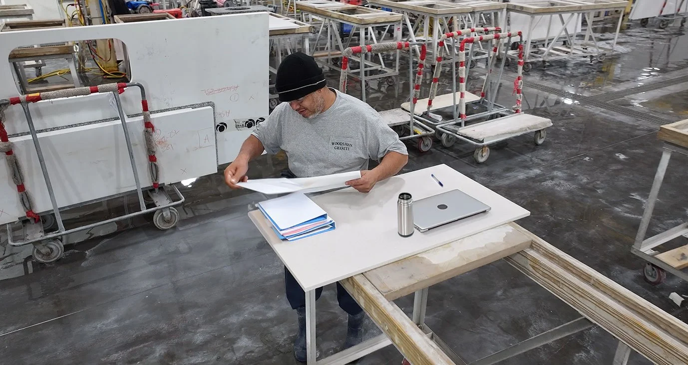 An employee owner looking over drawings in the warehouse at Woodsman.