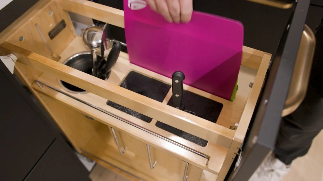 Kitchen drawer with built-in vertical storage organizers for cutting boards, baking sheets, knives, and utensils, maximizing cabinet organization and easy access.