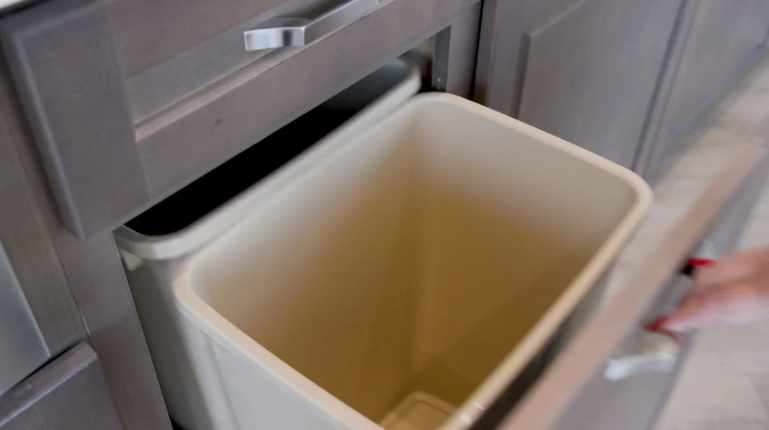 Kitchen base cabinet with a built-in pull-out double trash bin, providing concealed waste and recycling storage for a cleaner, more organized kitchen.