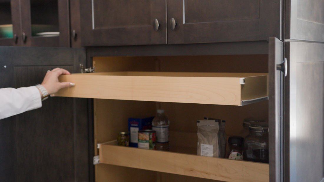 Tall kitchen pantry cabinet with full-extension wood pull-out shelves, providing easy access to pantry items and maximizing storage organization.