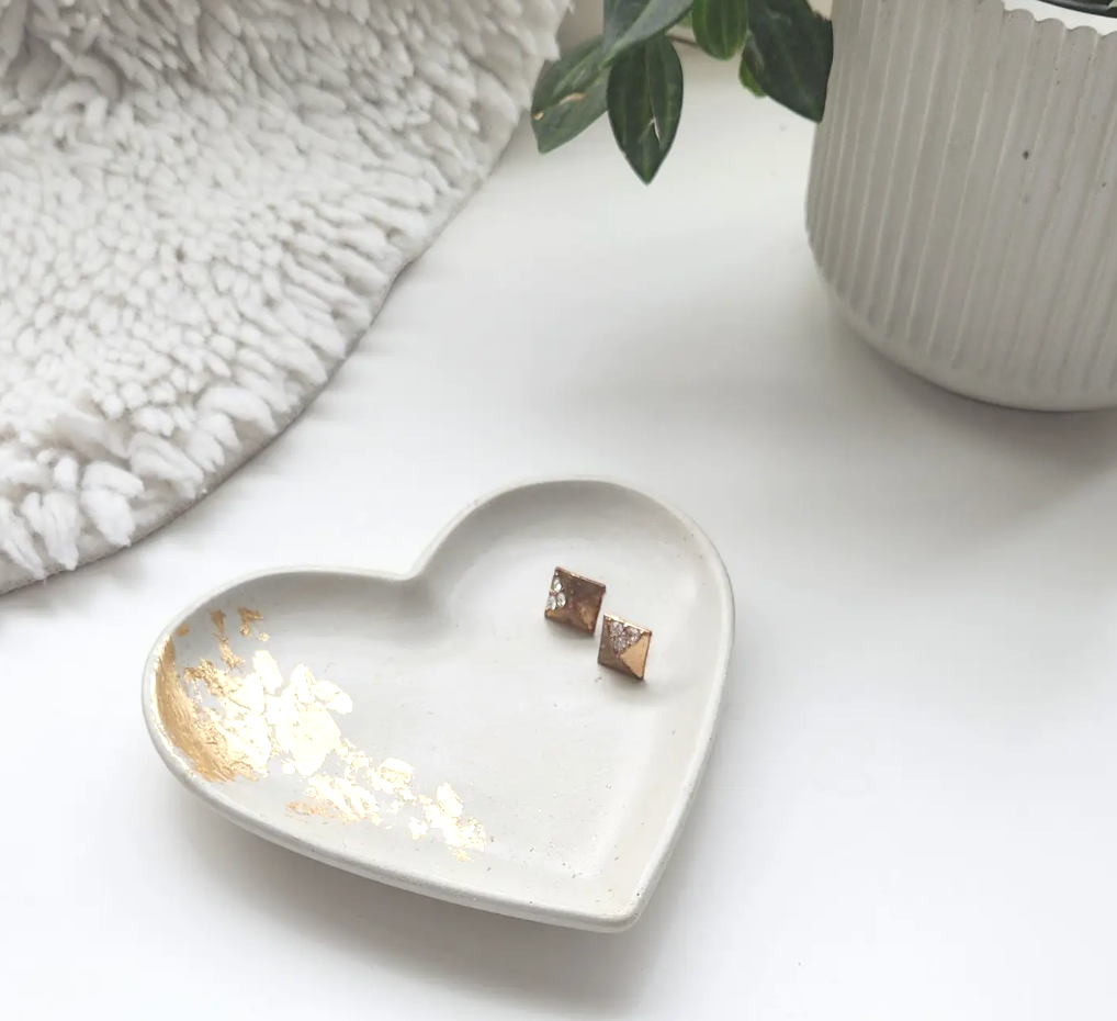A heart-shaped dish adorned with delicate gold leaf accents, showcasing an elegant and artistic design.