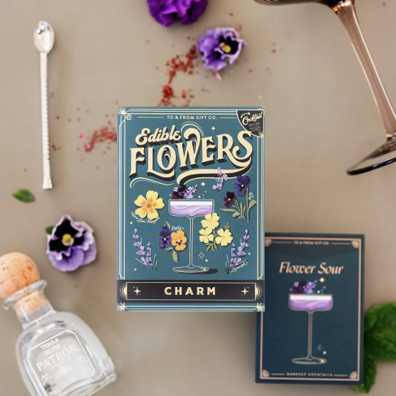 A book rests beside a glass of wine and a bouquet of flowers, creating a cozy and inviting atmosphere.