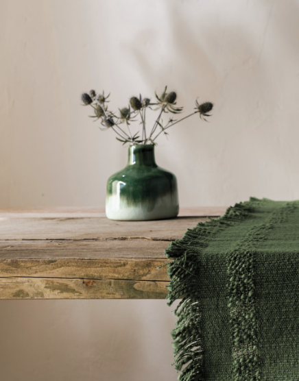 A vibrant green tablecloth drapes elegantly over a table, adding a fresh touch to the setting.