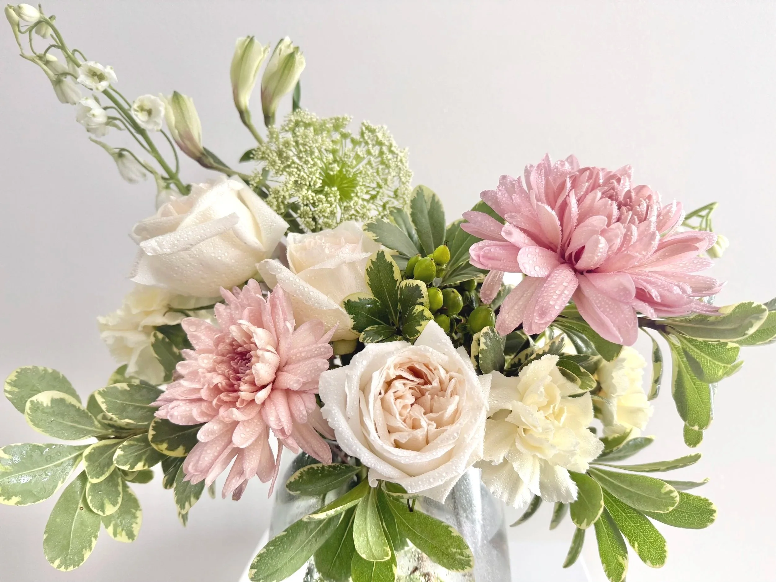 A vase filled with delicate pink and white flowers, showcasing a harmonious blend of colors and textures.